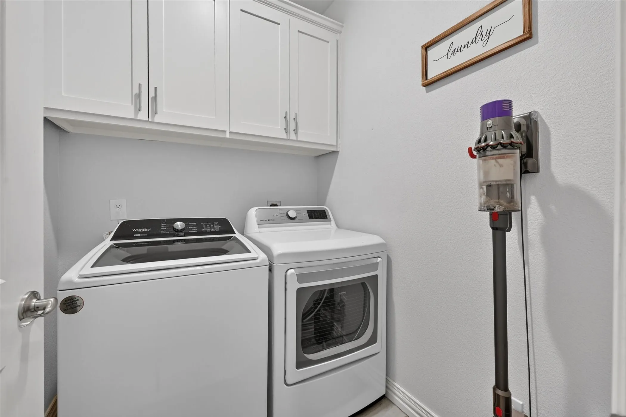 Utility room featuring white cabinetry with brushed nickel hardware and light gray wall paint