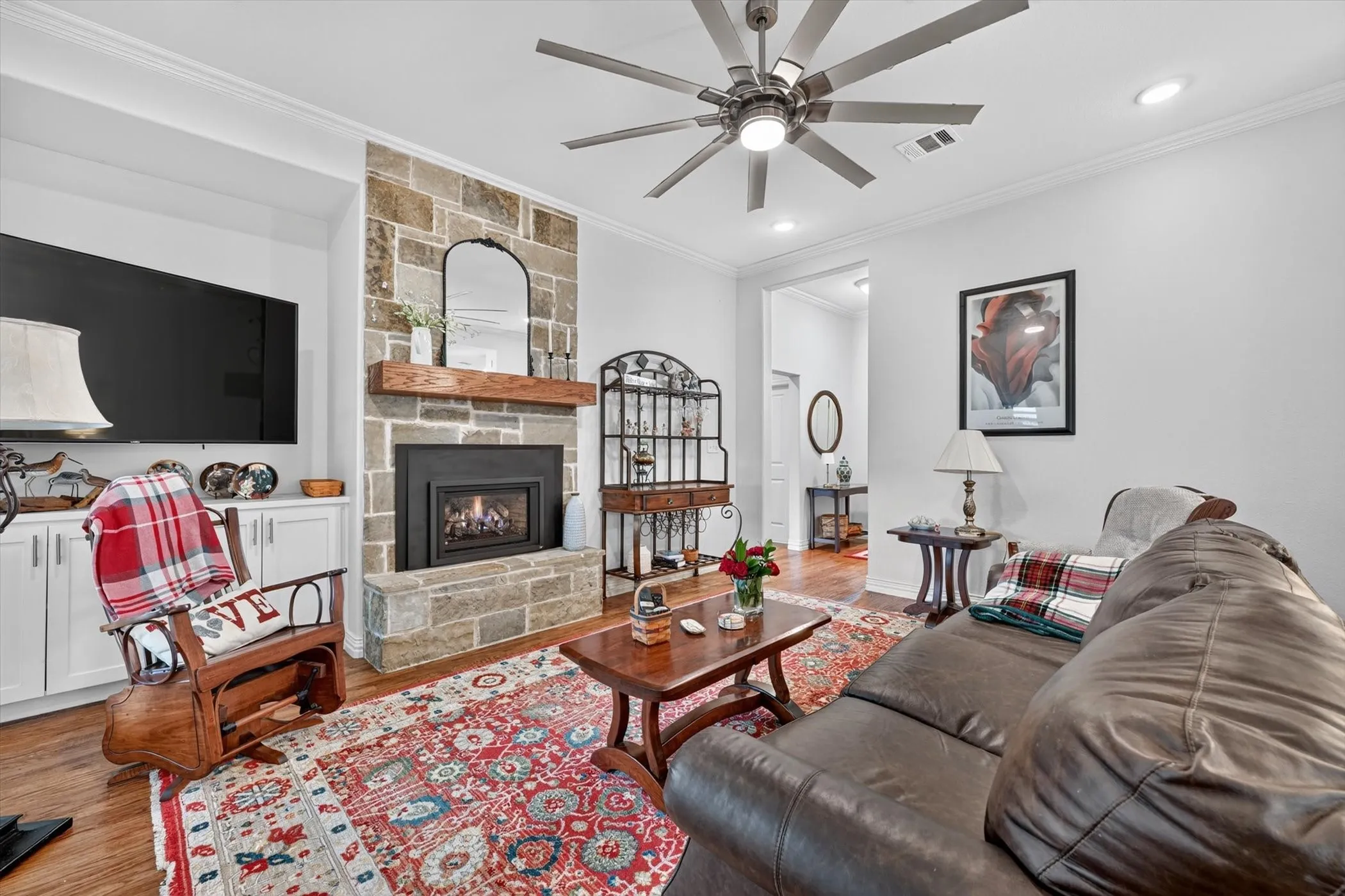 Living area featuring a floor-to-ceiling stone fireplace with a wood-beam mantel