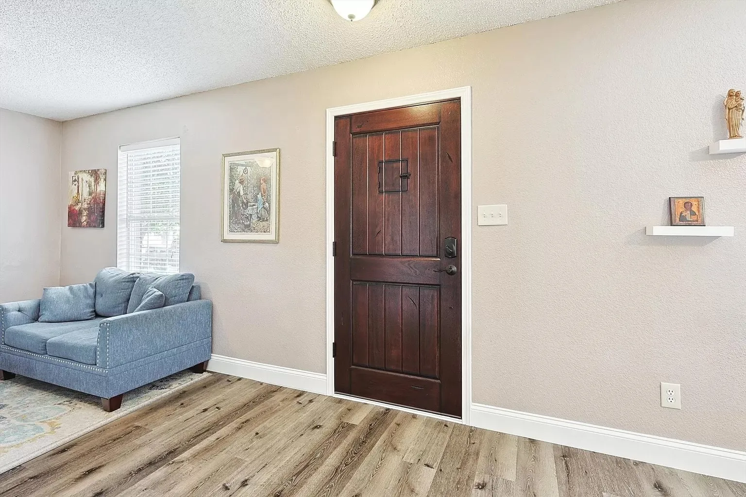 Rich wood-paneled door with dark hardware, set against light-colored walls