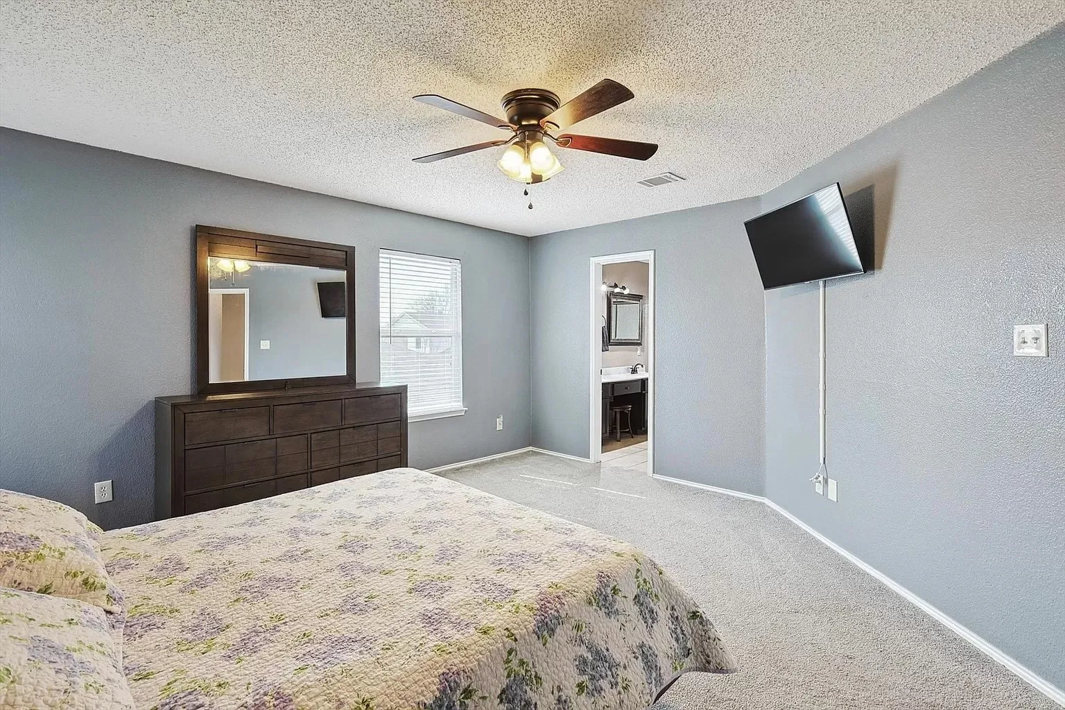 Spacious room with light gray walls and carpeted flooring
