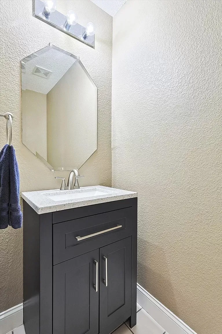 Contemporary vanity featuring a dark finish, integrated sink, and brushed nickel fixtures