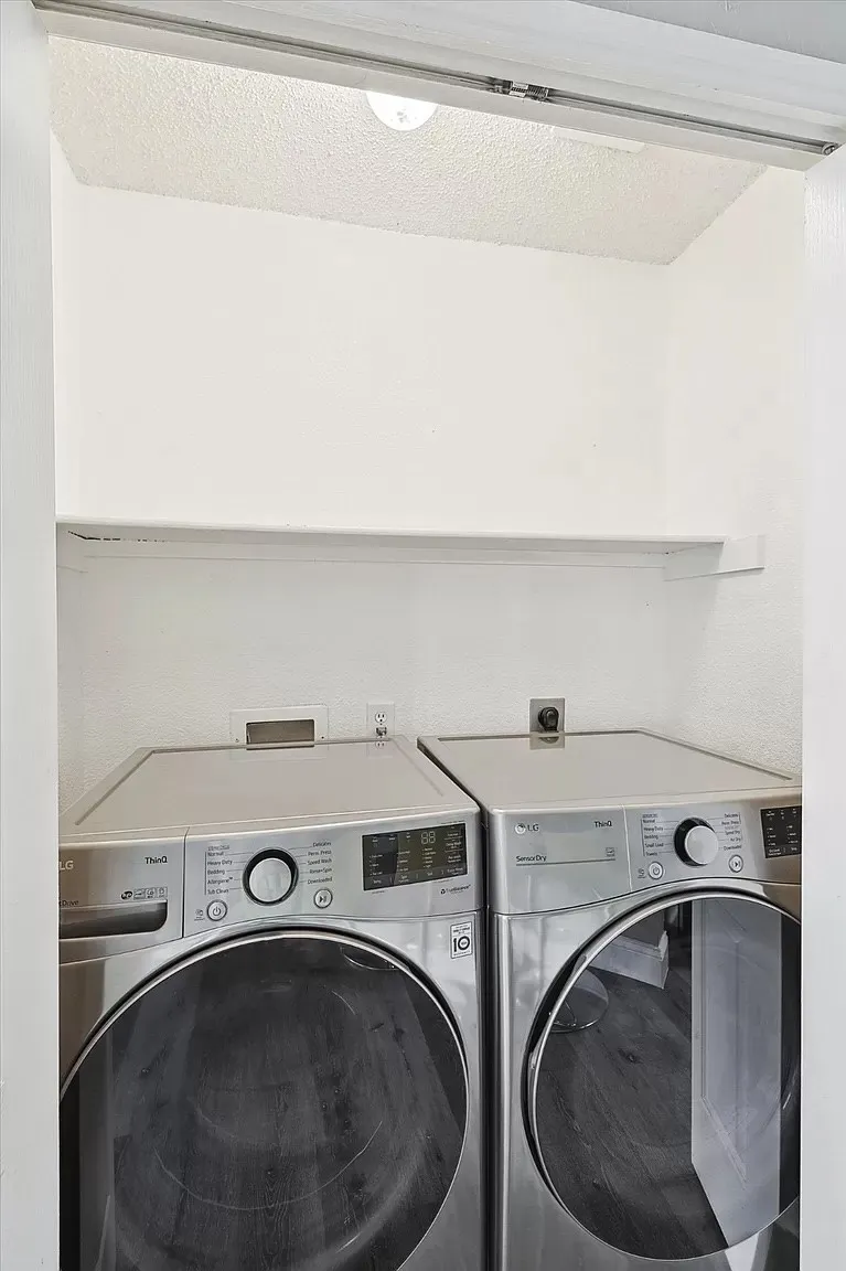 Dedicated laundry area featuring a built-in shelf, overhead lighting, and white walls