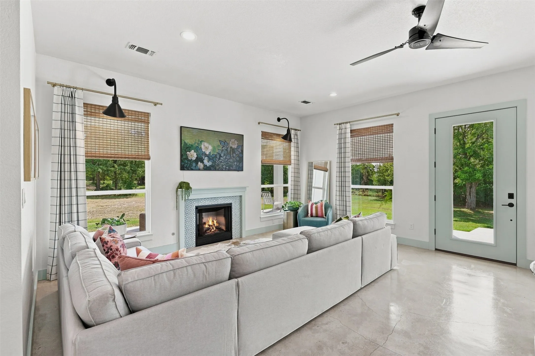 Living area features concrete floors, natural light and gas logs fireplace.