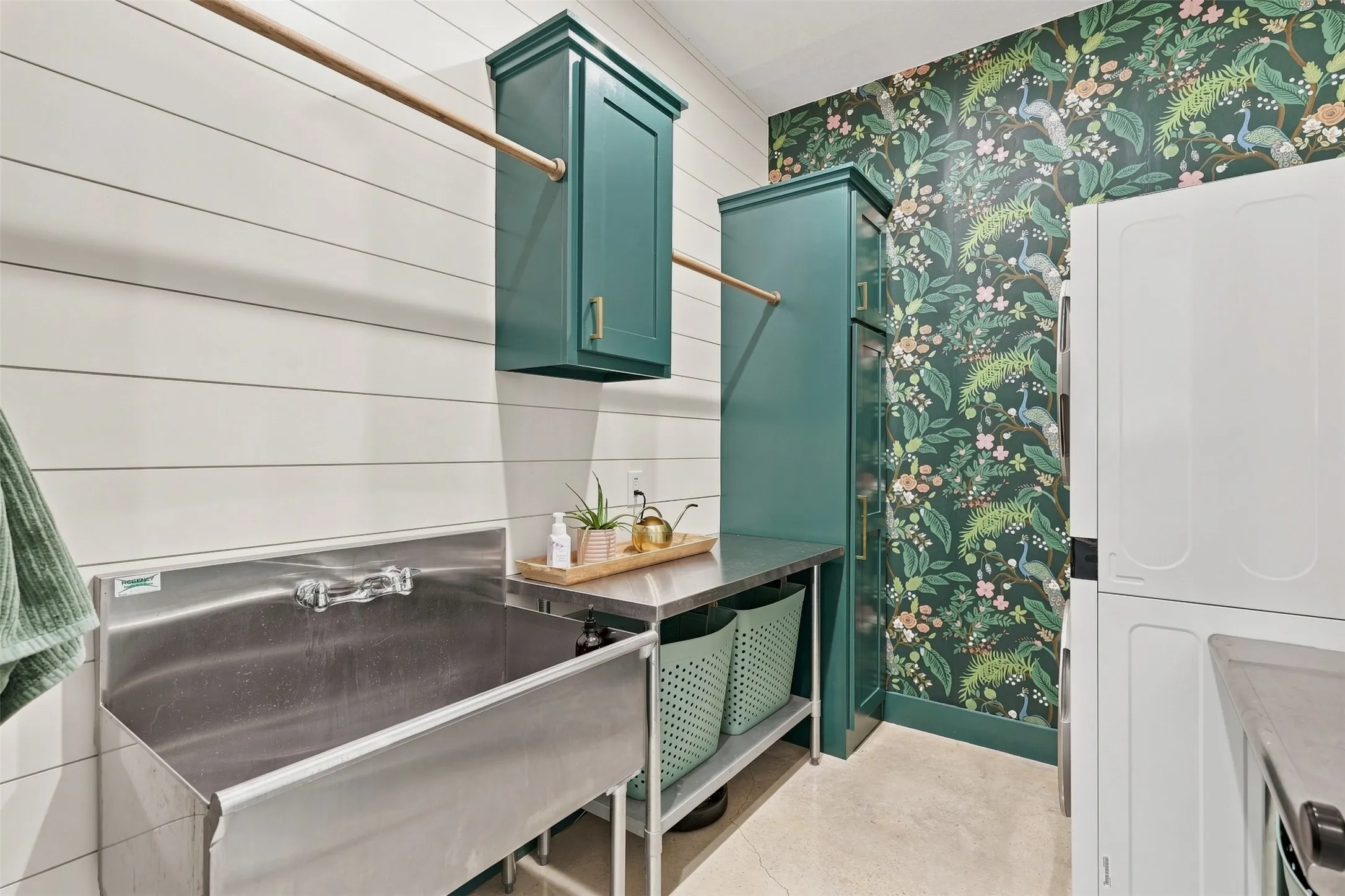 Spacious downstairs utility area with large utility sink, hanging racks and built-in cabinets.