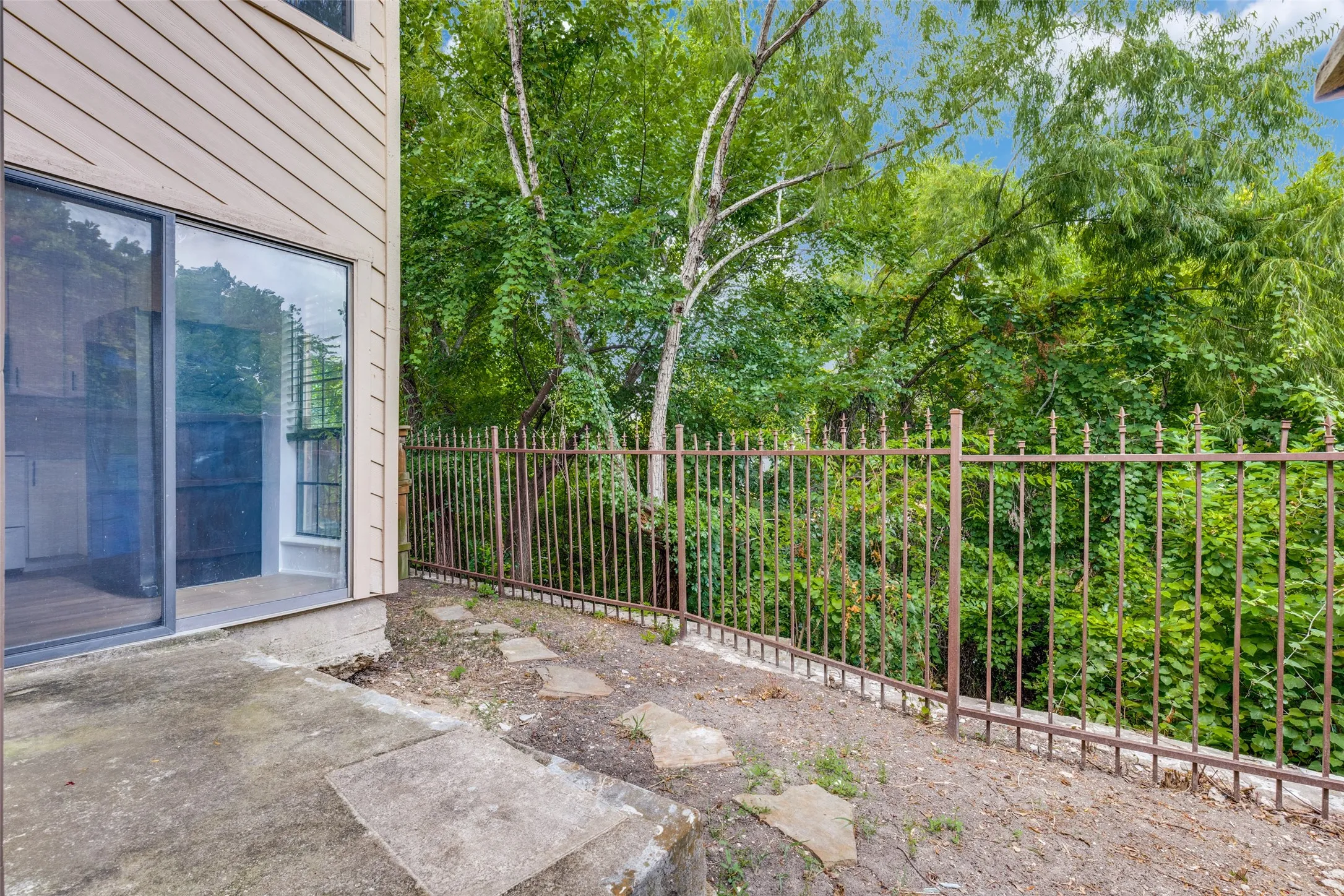 Ground-level patio with sliding glass door entry to interior space