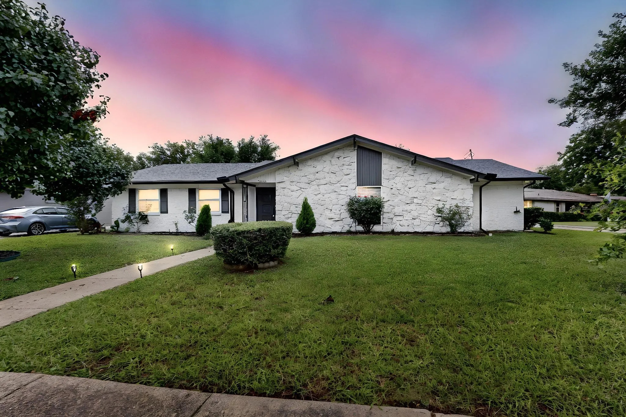 View of front of house with a yard and stone siding