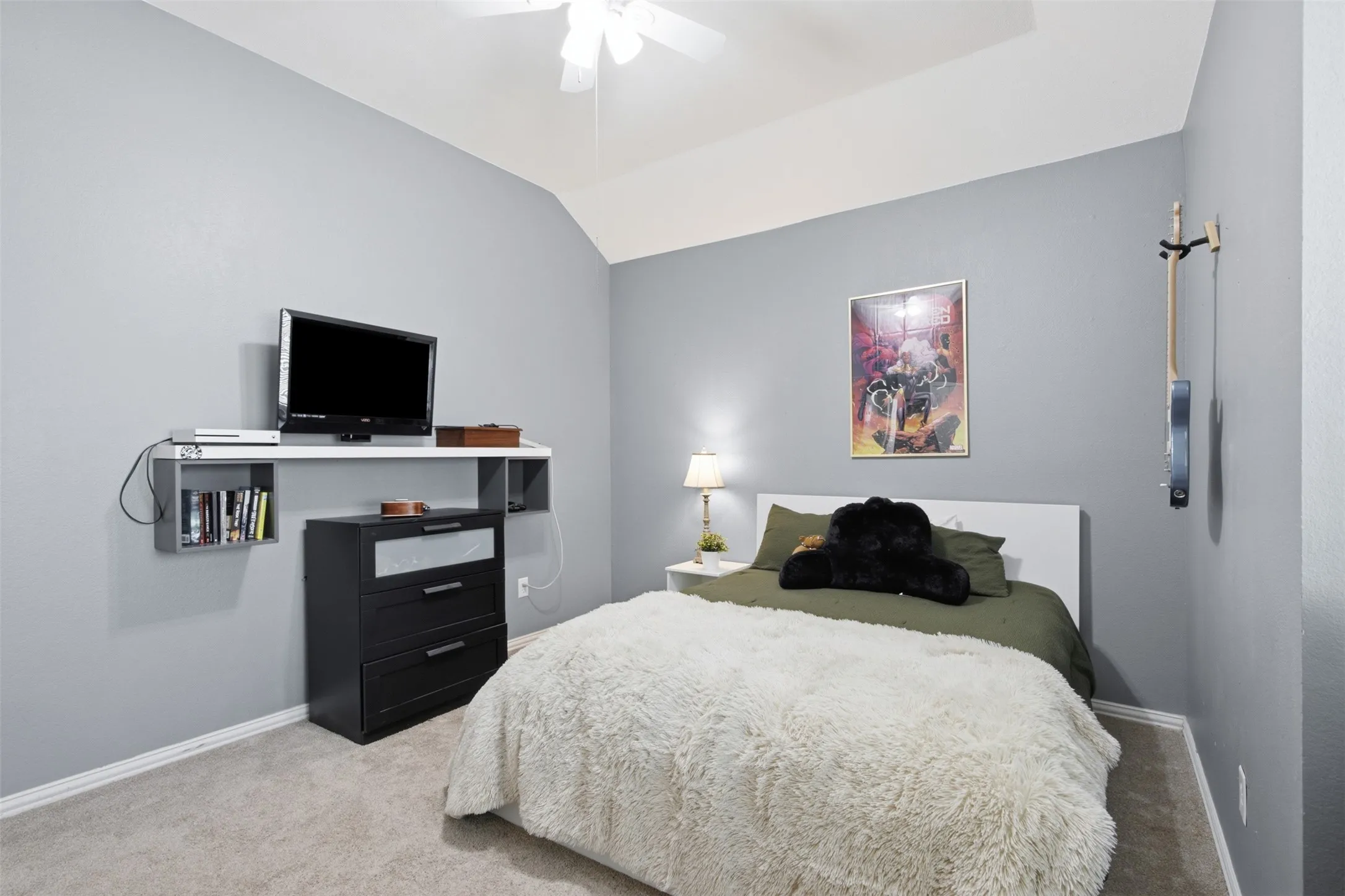 Carpeted bedroom with vaulted ceiling and a ceiling fan