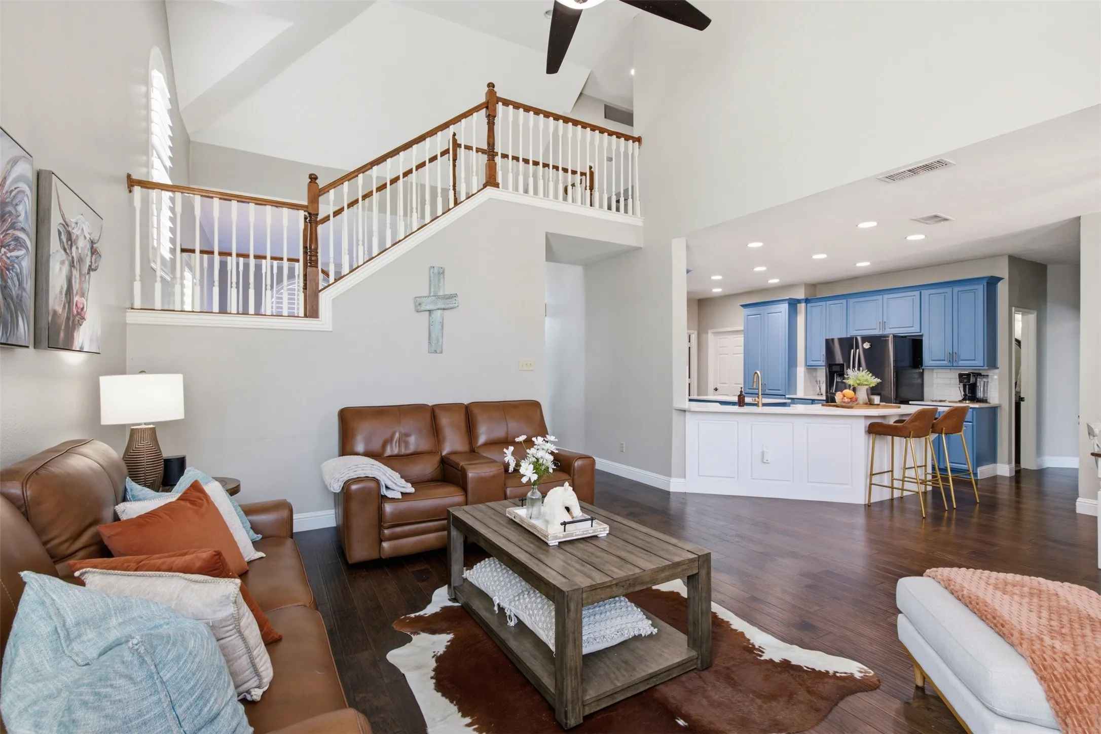 Open-concept living area with dark wood-finish flooring and soaring​​‌​​​​‌​​‌‌​‌‌​​​‌‌​‌​‌​‌​​​‌​​ ceilings