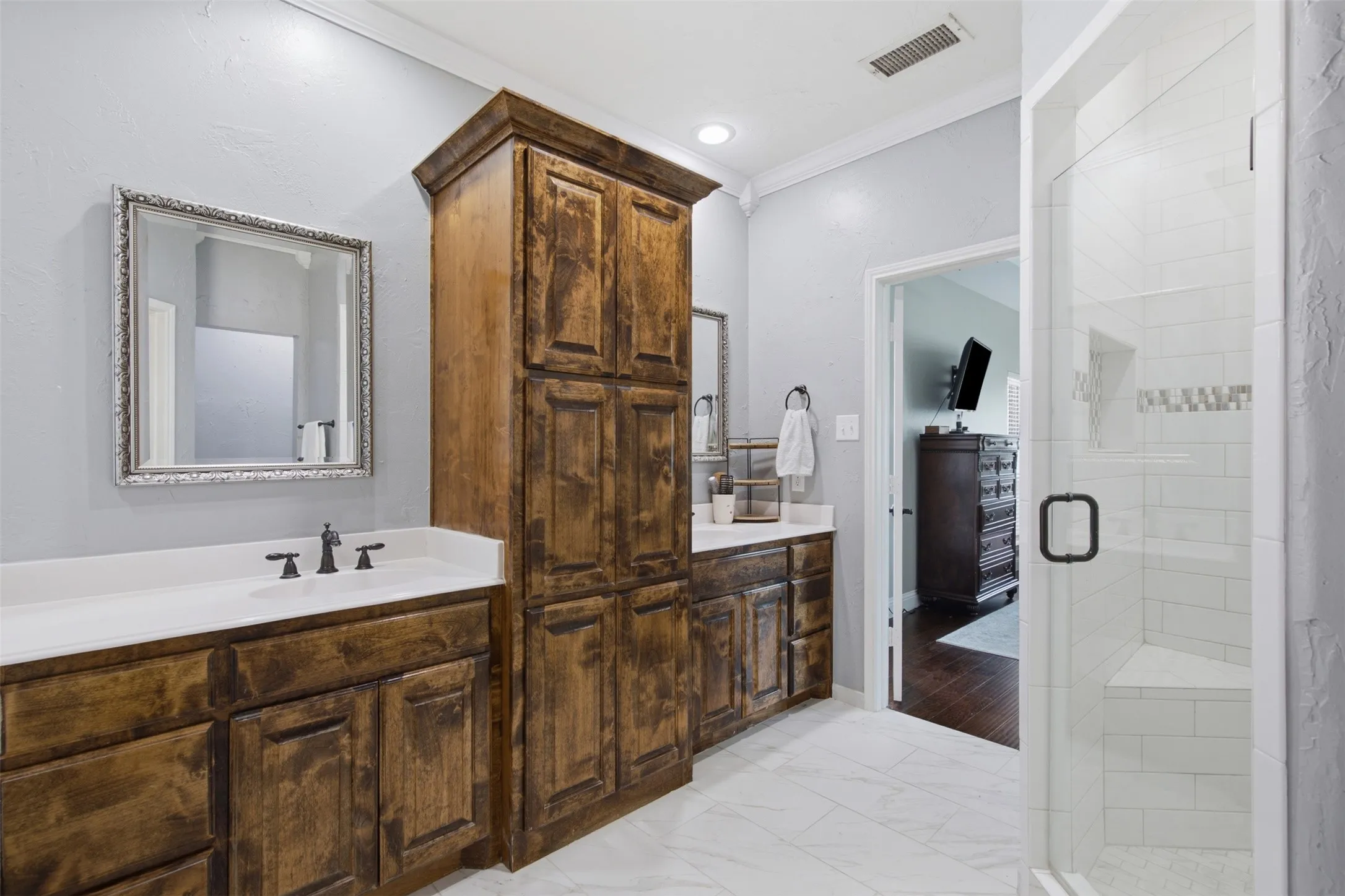 Dual wood-finish vanities with white countertops and undermount sinks