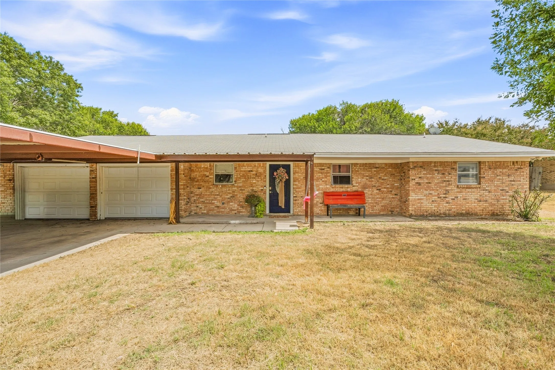 Brick exterior with a covered front entry and a two-car carport