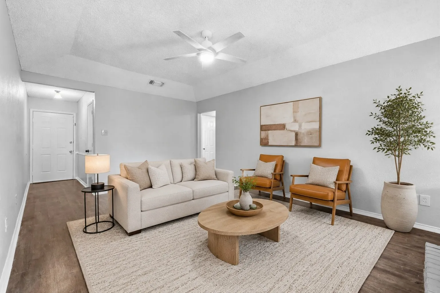 Virtually Staged Vaulted ceiling with a ceiling fan, wood-finish flooring, and light gray wall paint