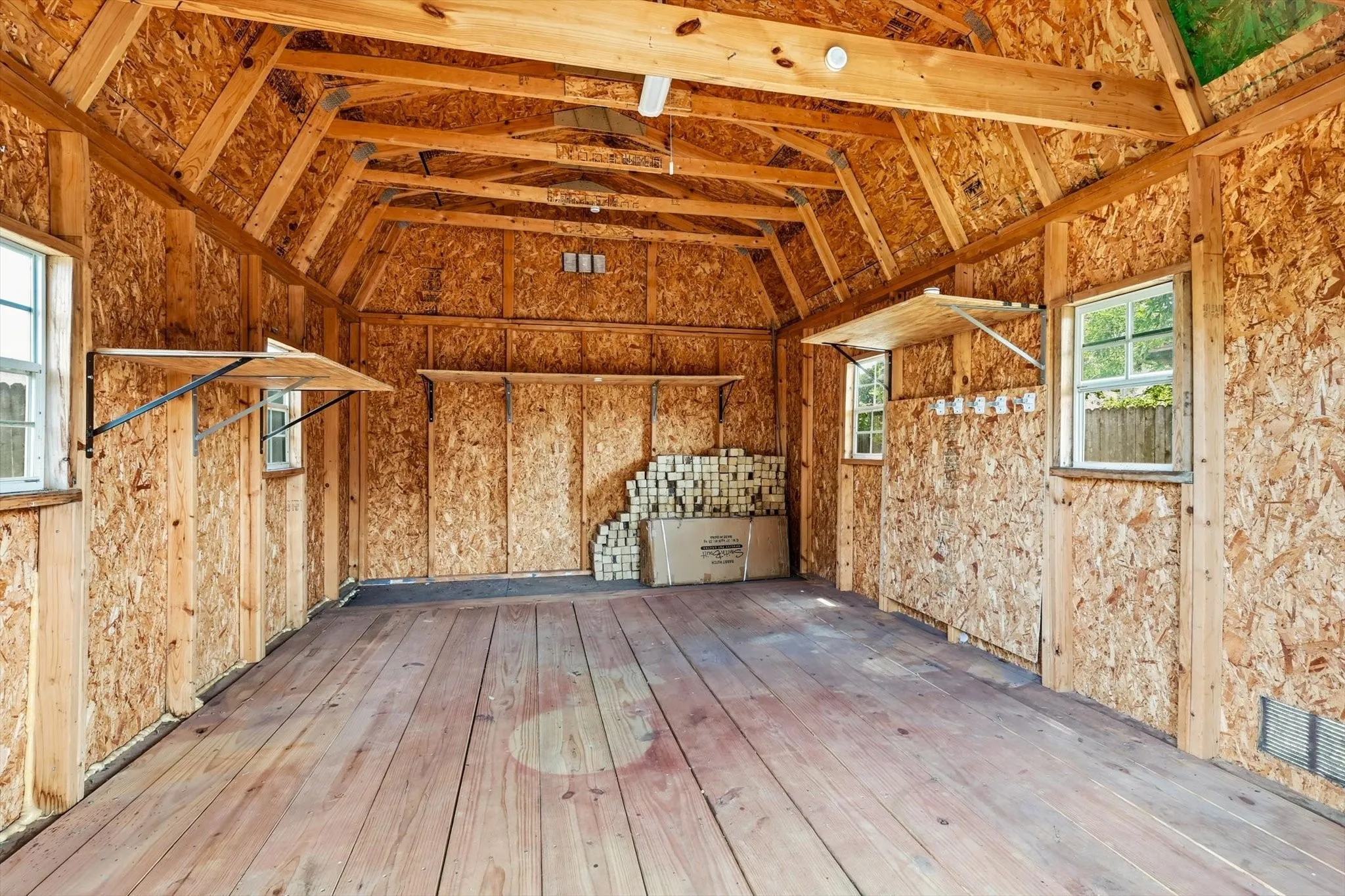 Interior structure featuring exposed wood framing, oriented strand board walls, and wood plank flooring