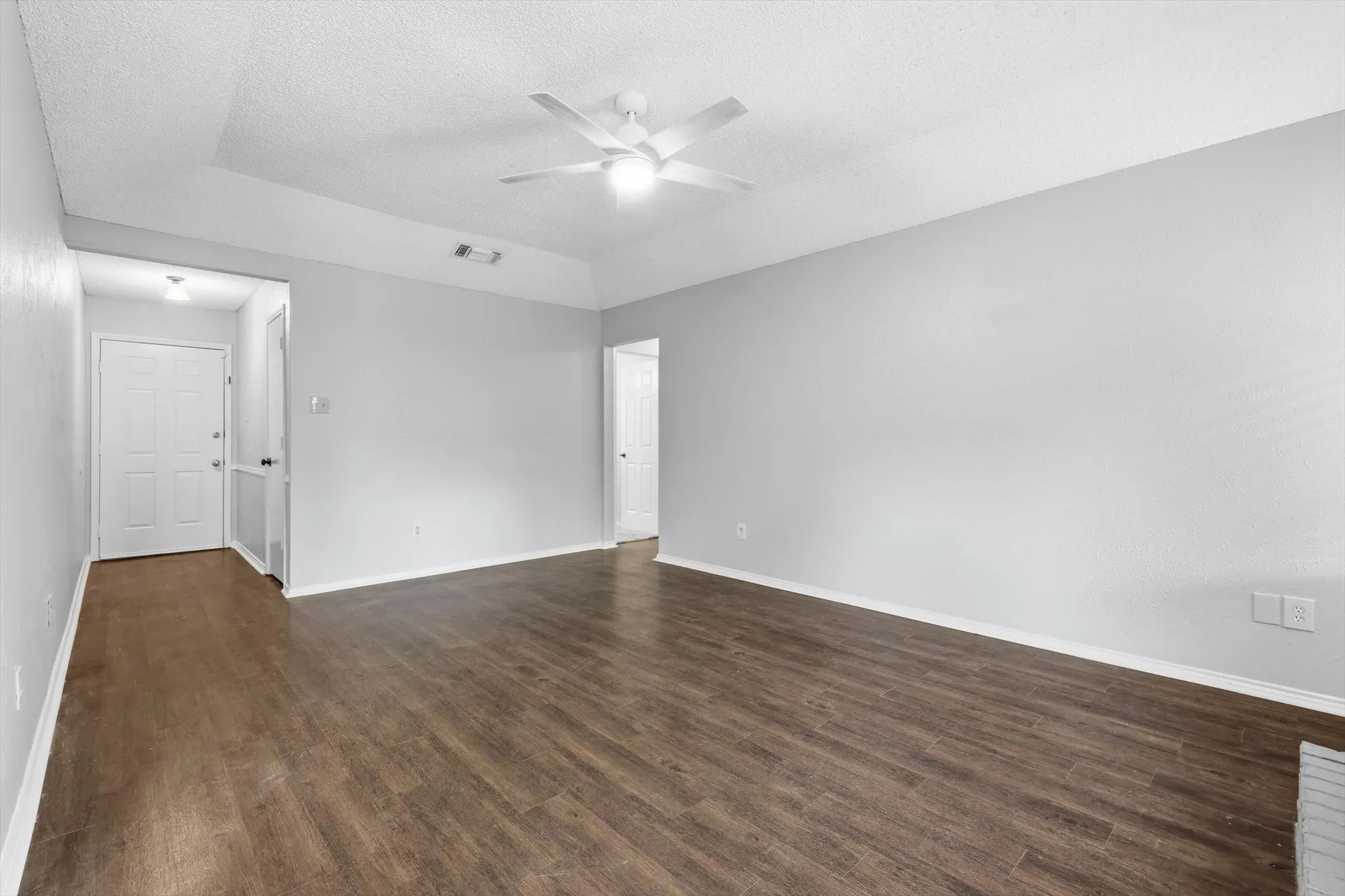 Bright living area featuring wood-finish flooring, light gray wall paint, and white trim