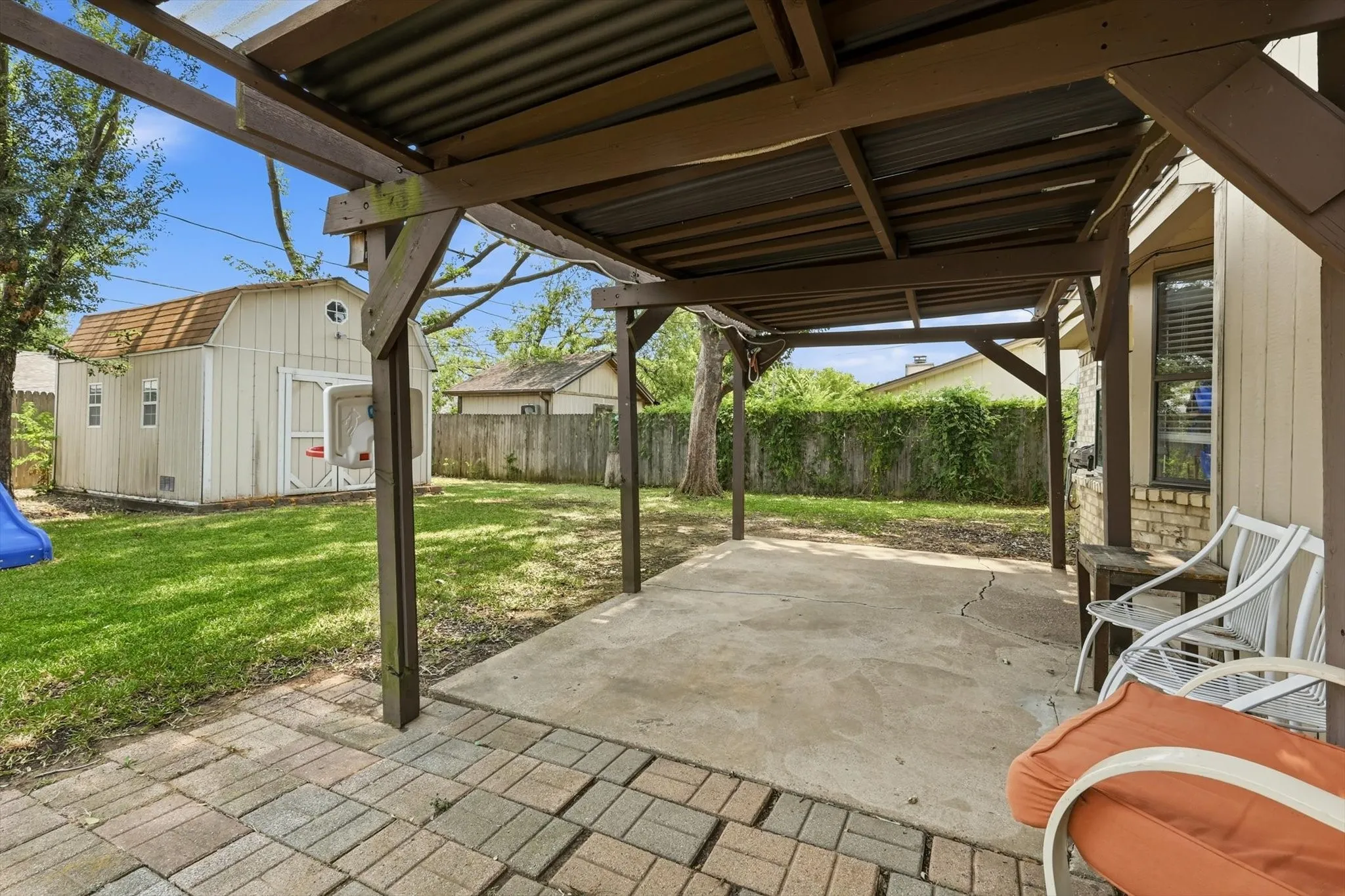 Covered patio with a concrete slab and a brick paver extension
