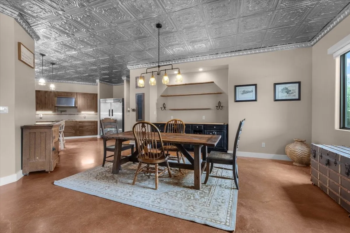 Dining area featuring a pressed metal ceiling with crown molding, a multi-light chandelier, and integrated shelving