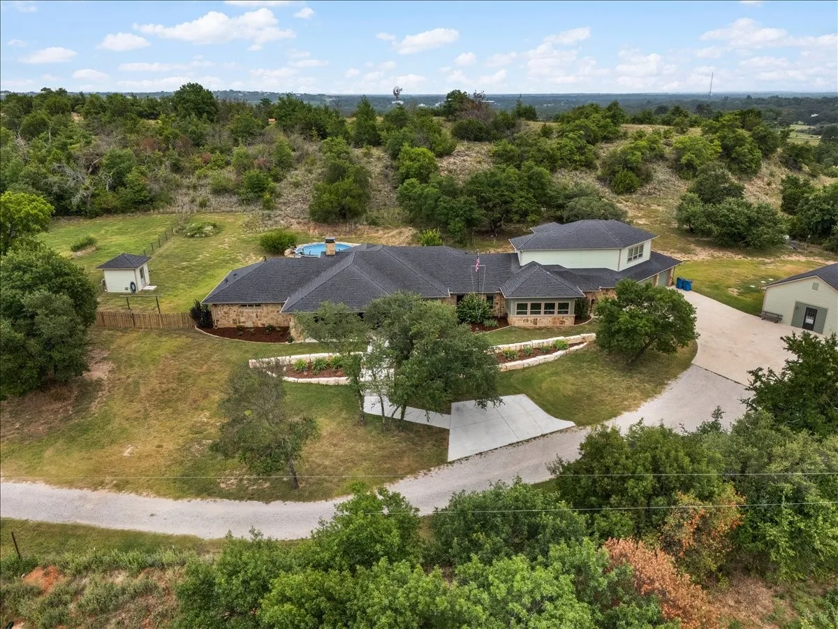 Expansive property featuring a stone and siding exterior, a circular swimming pool, and a detached structure