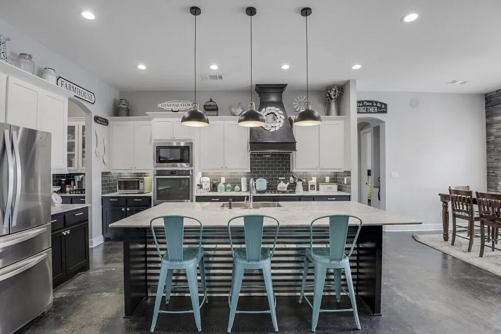 Contemporary kitchen featuring a large island with a light-toned countertop and corrugated metal detailing