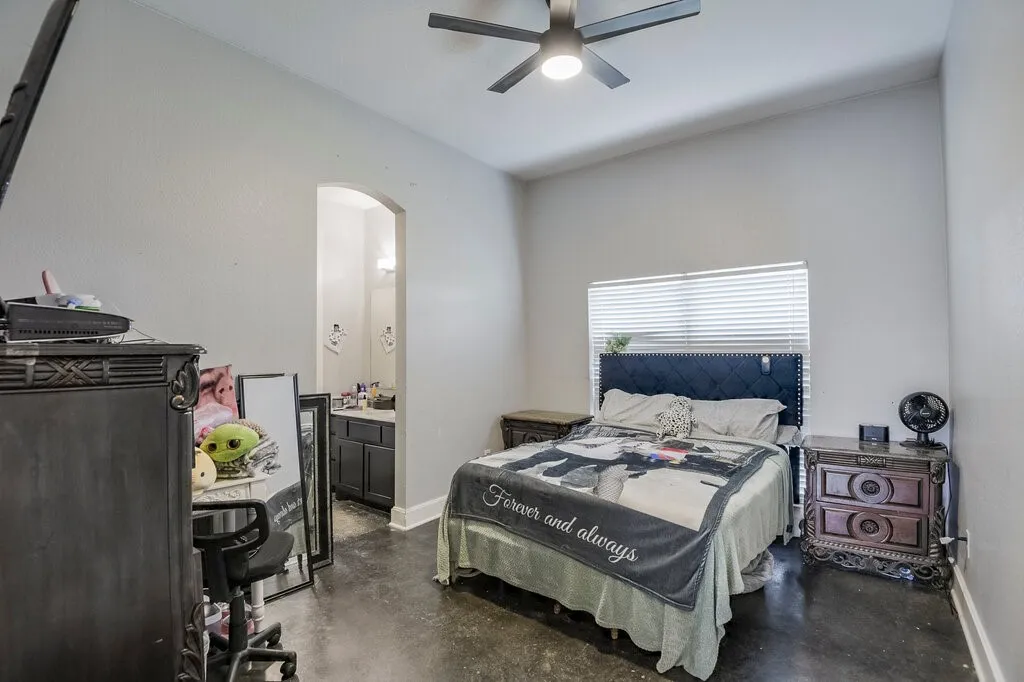 Spacious room featuring vaulted ceilings, a ceiling fan with integrated lighting, and a window with horizontal blinds