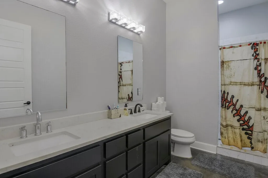 Bathroom featuring a double vanity with light-toned countertops, dark cabinetry, and dual sinks