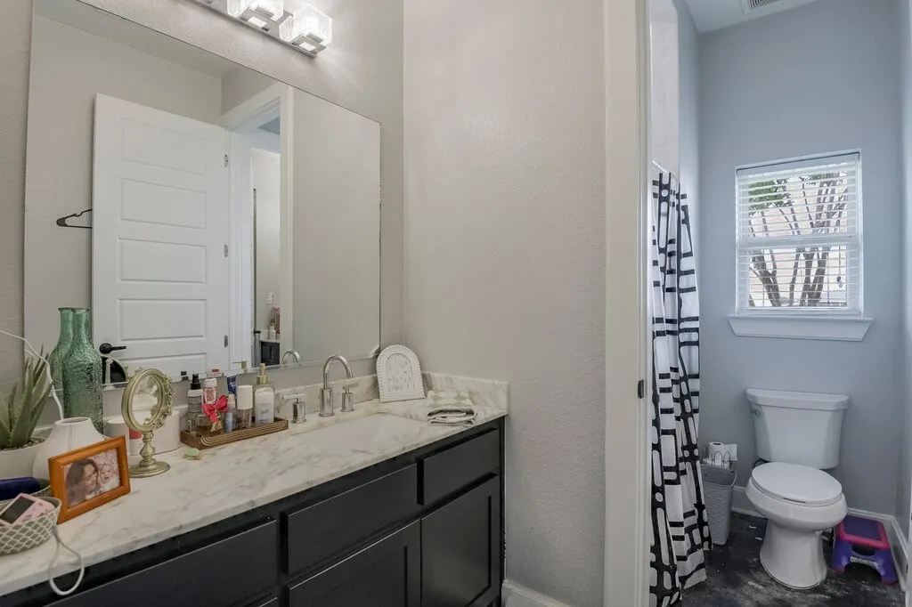 Bathroom featuring a dark wood vanity with a white stone countertop, undermount sink, and brushed nickel faucet