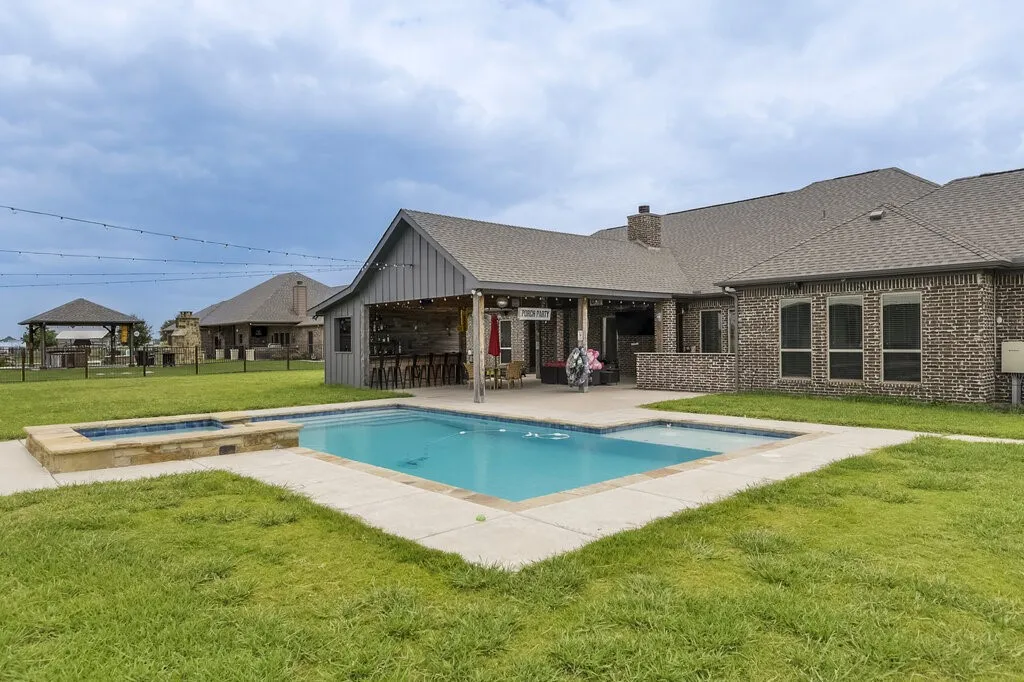 Outdoor living space featuring a rectangular swimming pool with an integrated spa