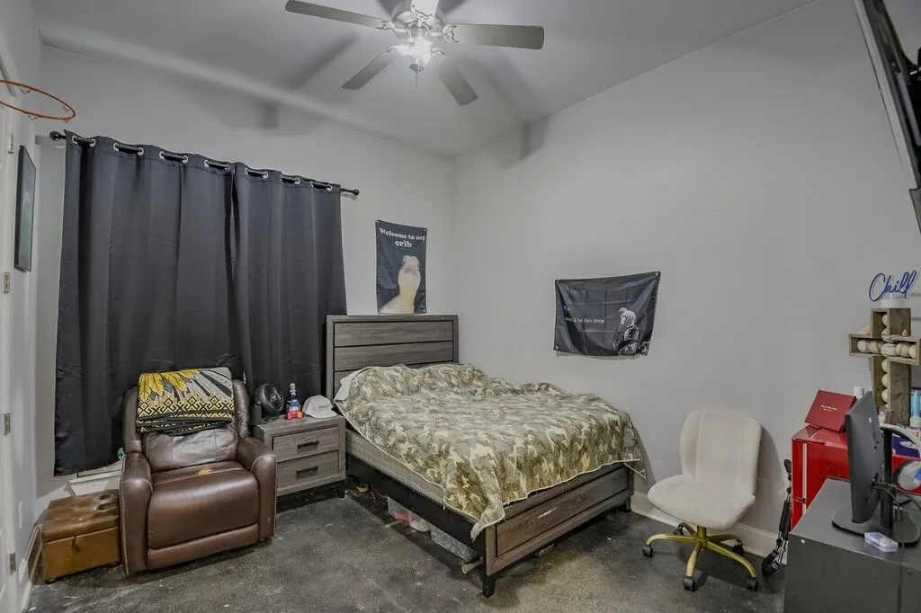Spacious room featuring light-colored walls and dark-toned flooring