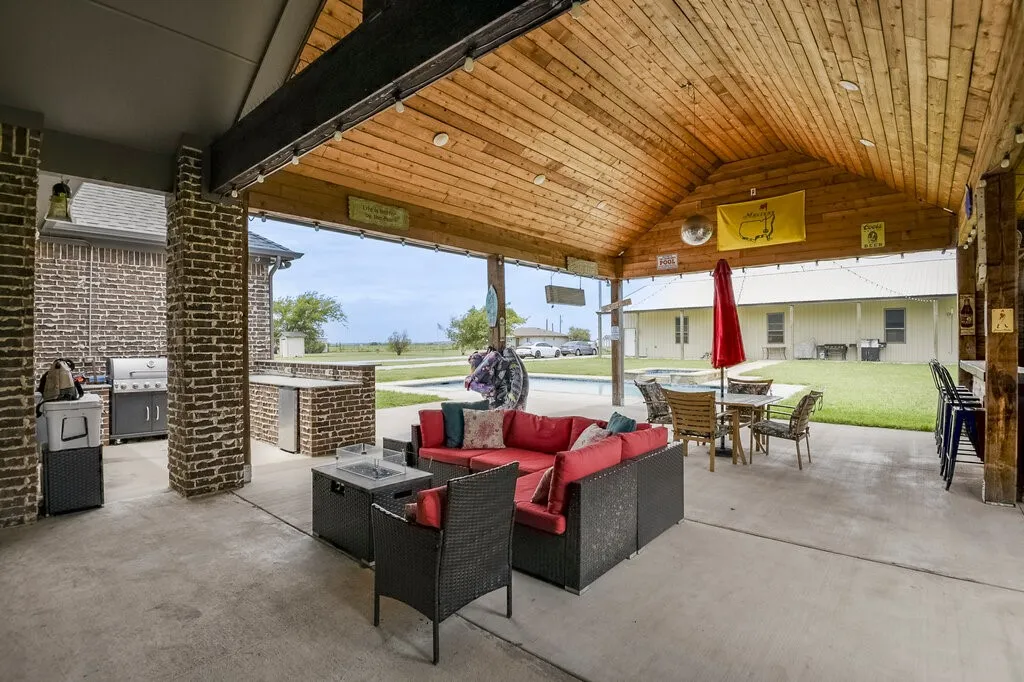 Expansive covered patio featuring a wood-finish vaulted ceiling with recessed lighting