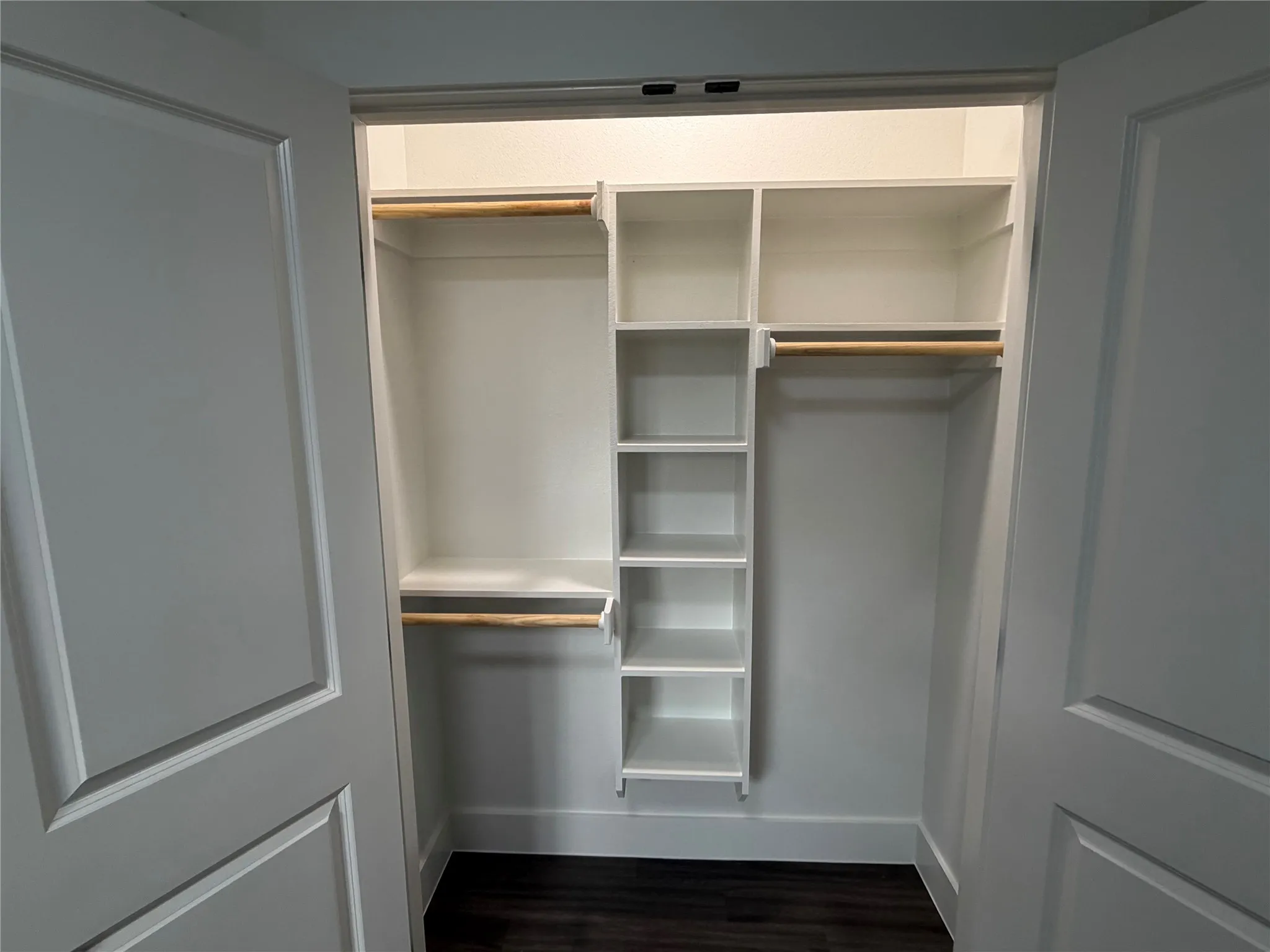 Well-organized closet featuring custom shelving and hanging rods