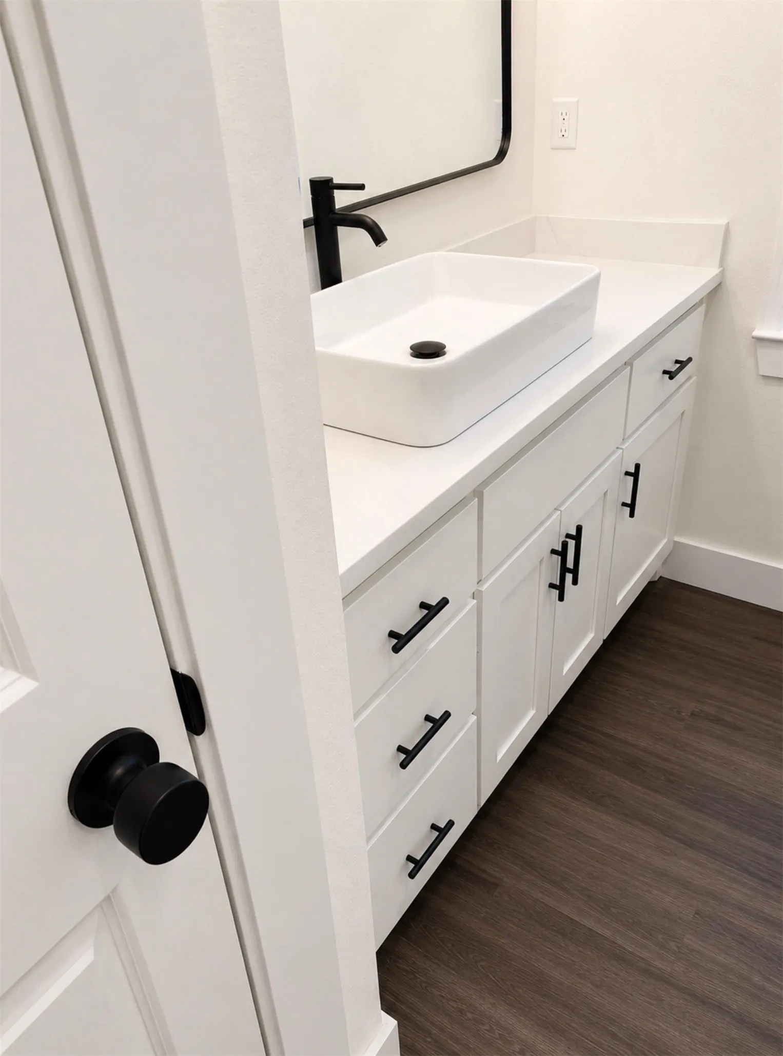 Bathroom vanity featuring a rectangular vessel sink, matte black faucet, and white countertop
