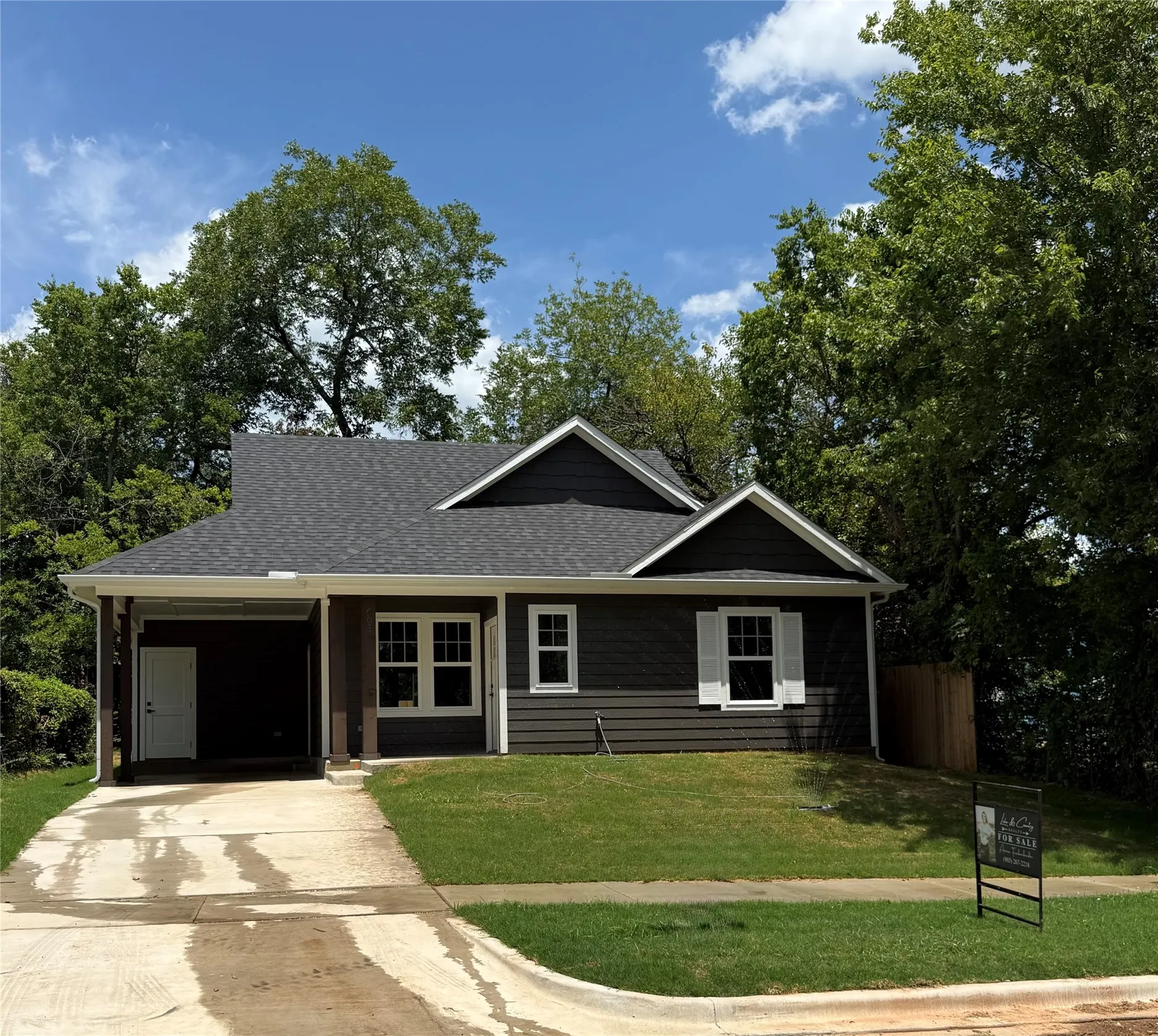 Contemporary dark gray siding exterior with white window trim and shutters