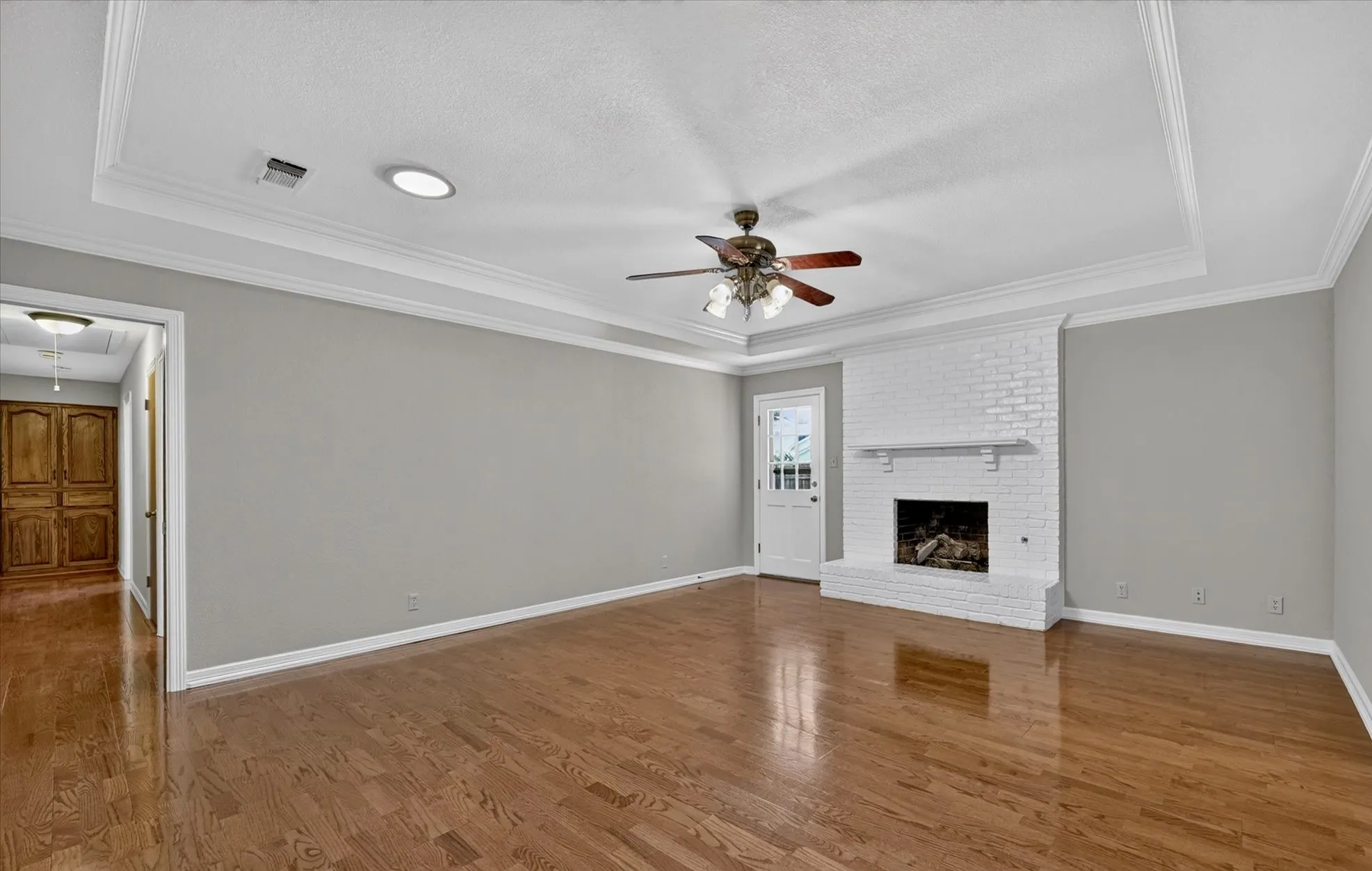 Spacious living room with matching architectural ceiling details, and wood/gas log fireplace