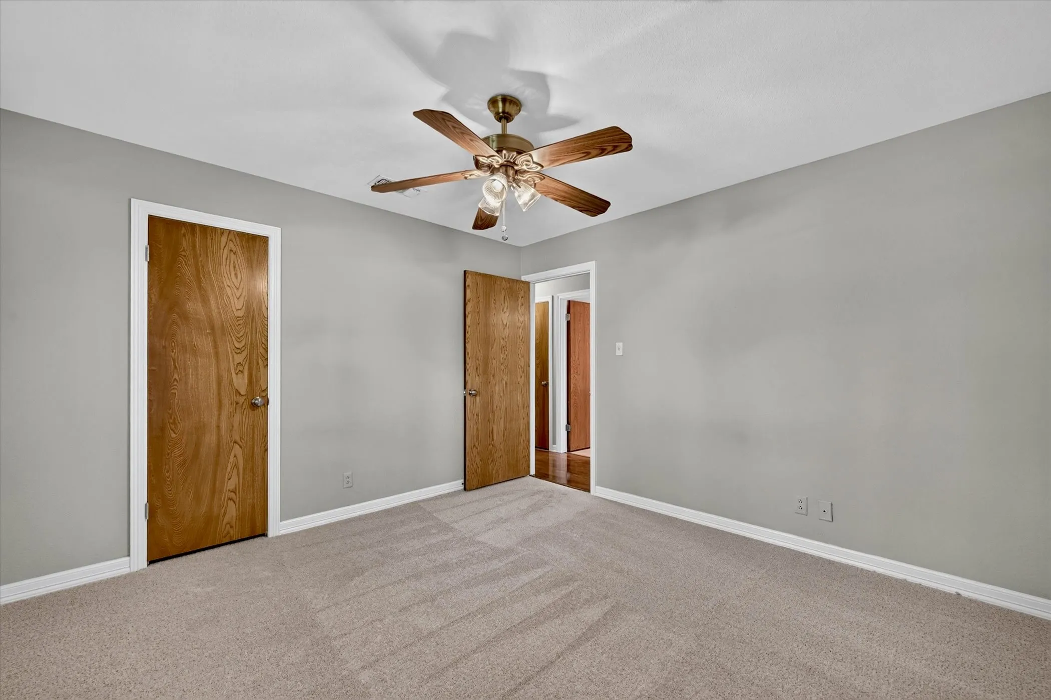 Generously sized secondary bedroom with fresh carpet, ceiling fan, and large closet.