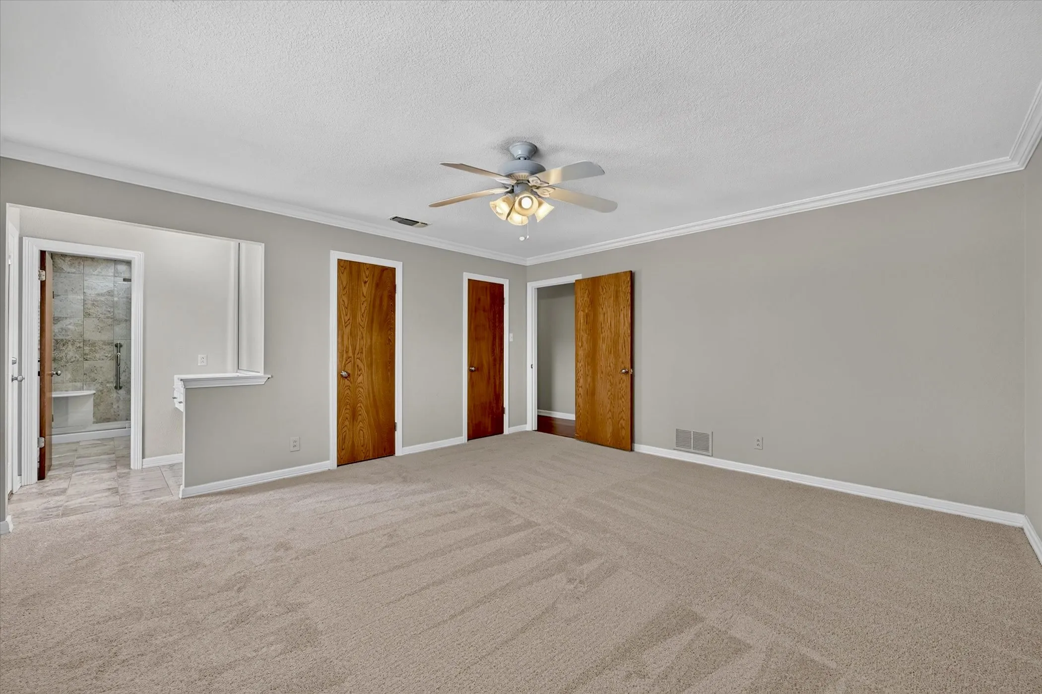 Primary bedroom with two closets and entry to bath and exterior doot to pool