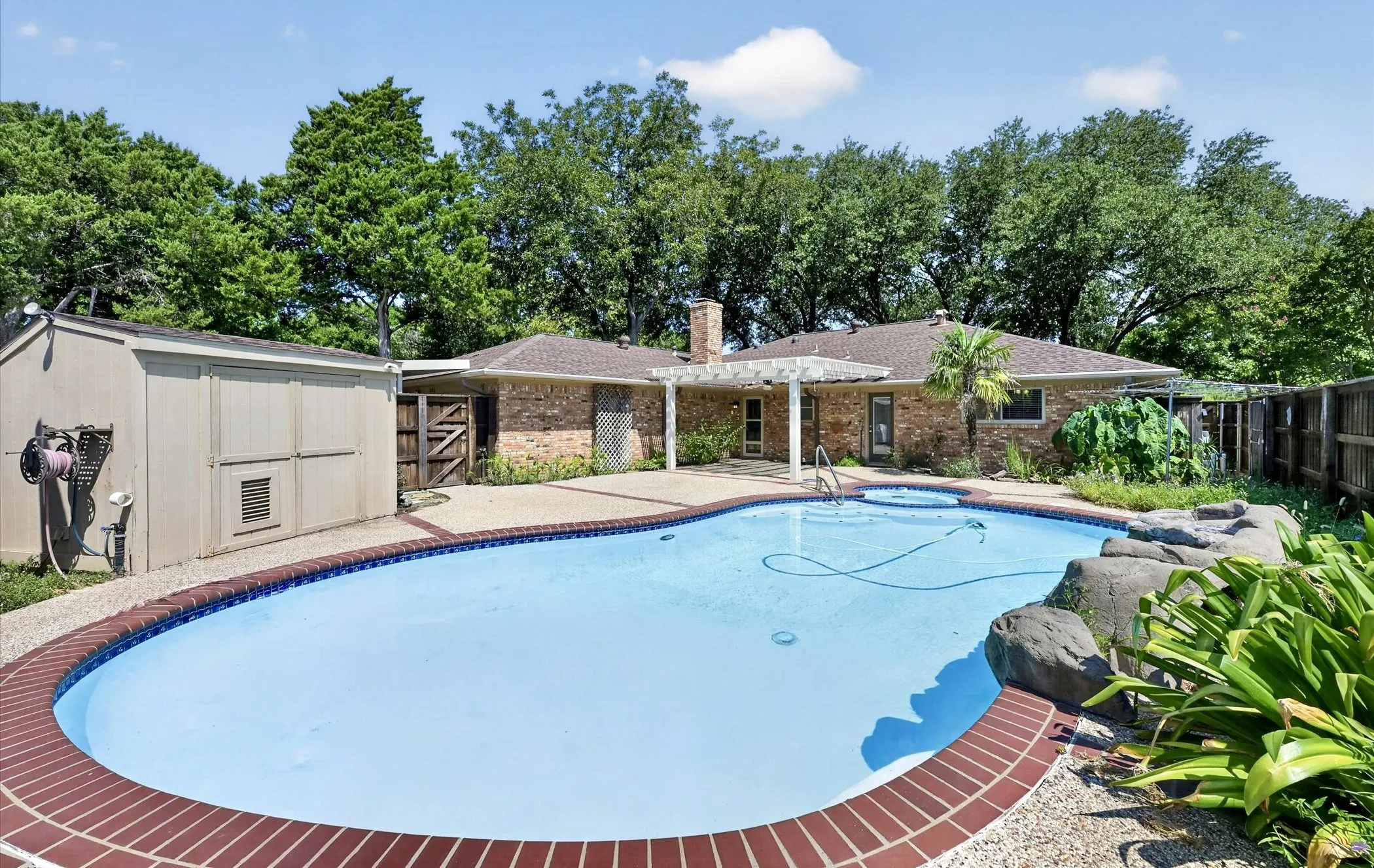 Large crystal-clear 6' deep swimming pool with relaxing spa and tranquil waterfall creates the perfect backyard retreat