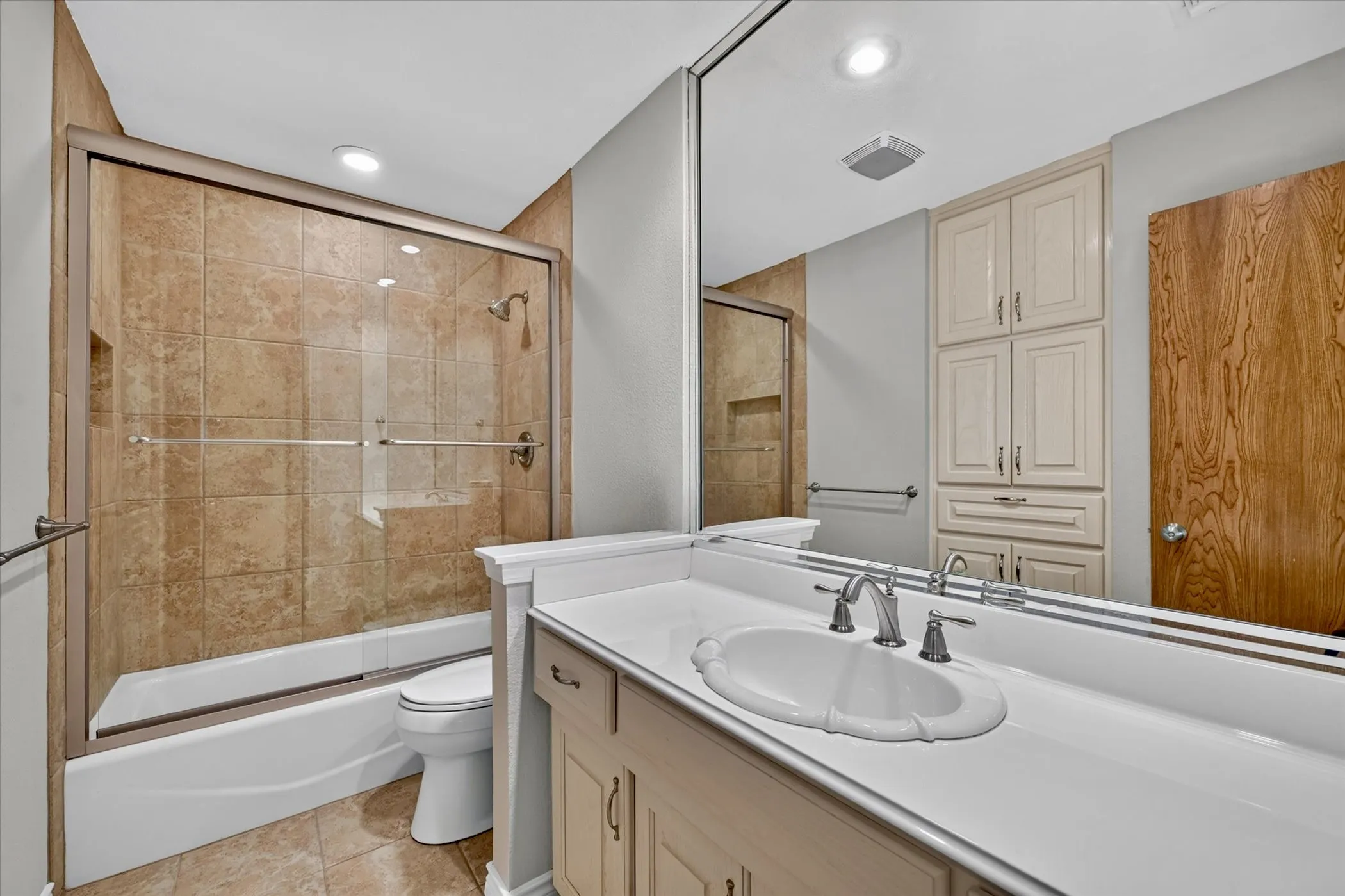 Updated secondary bath with custom tile surround, glass enclosure, and modern fixtures