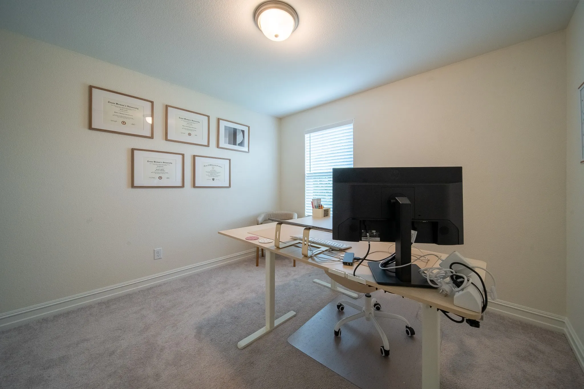 Carpeted room with a flush-mount ceiling light fixture, white baseboards, and a window with horizontal blinds