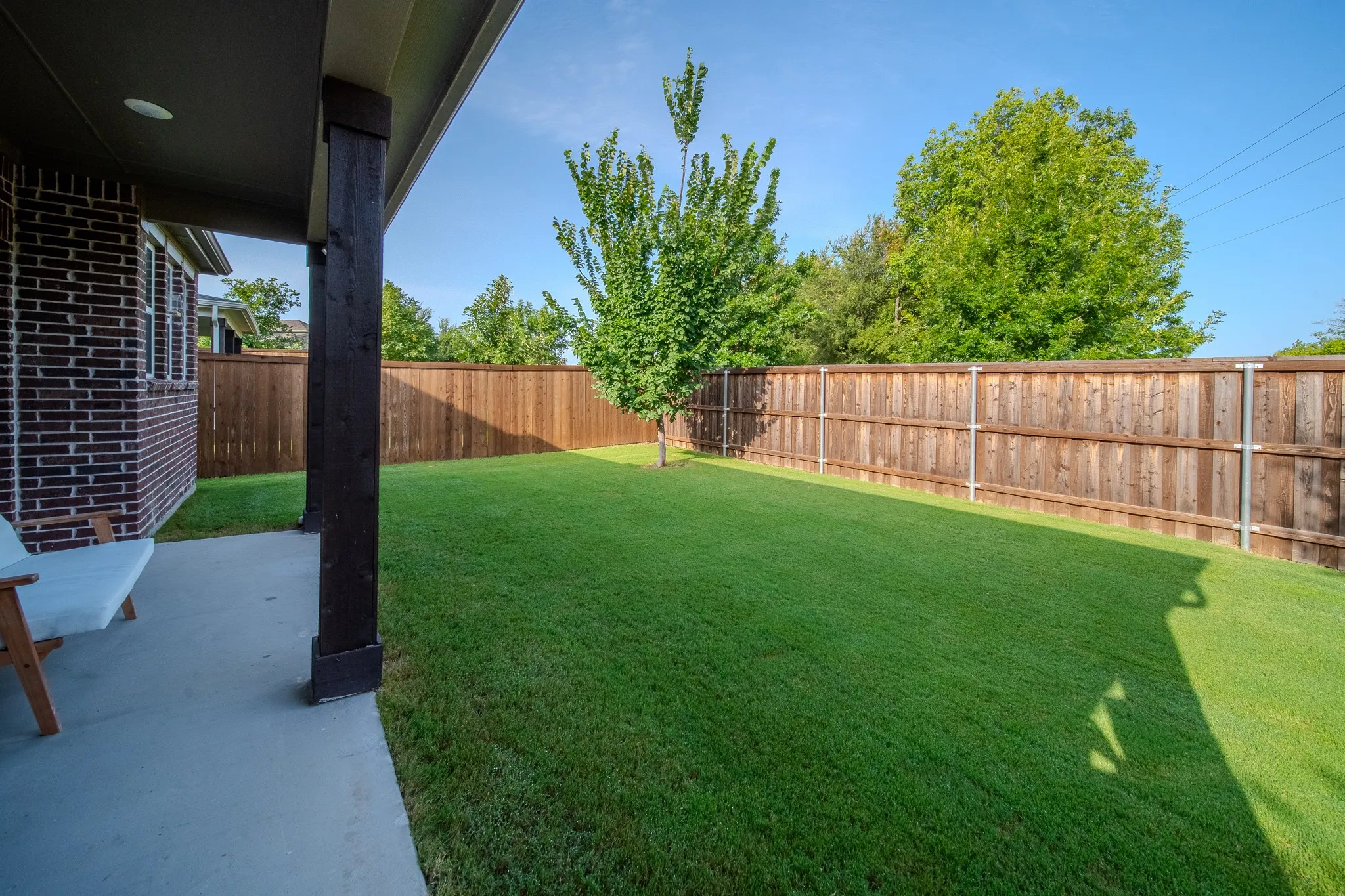 Expansive backyard featuring a lush lawn and a perimeter wood privacy fence