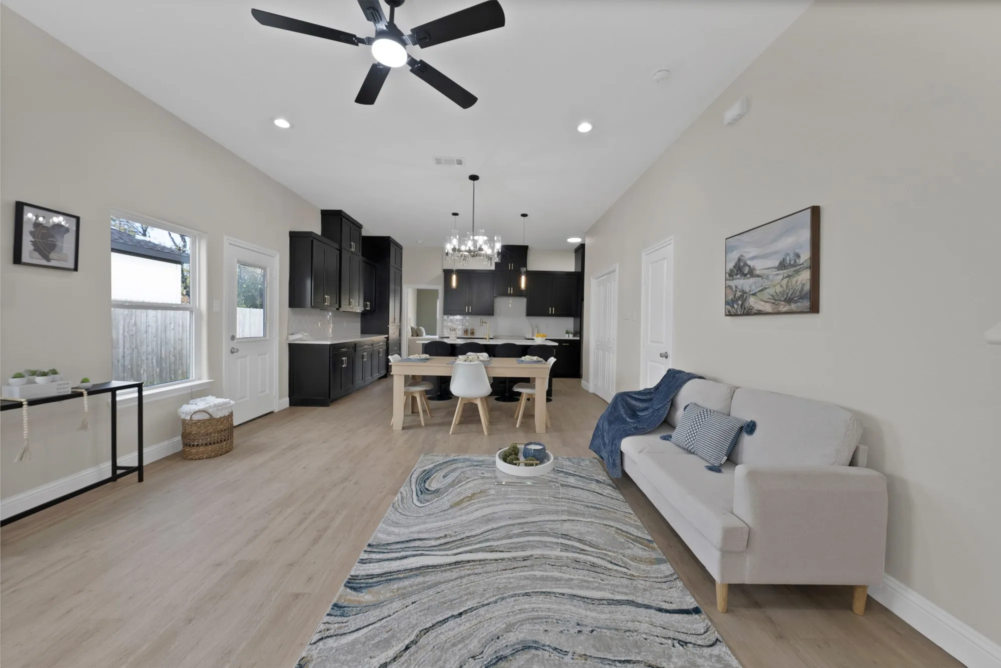 Open-concept living space featuring wood-finish flooring, recessed lighting, and a modern ceiling fan