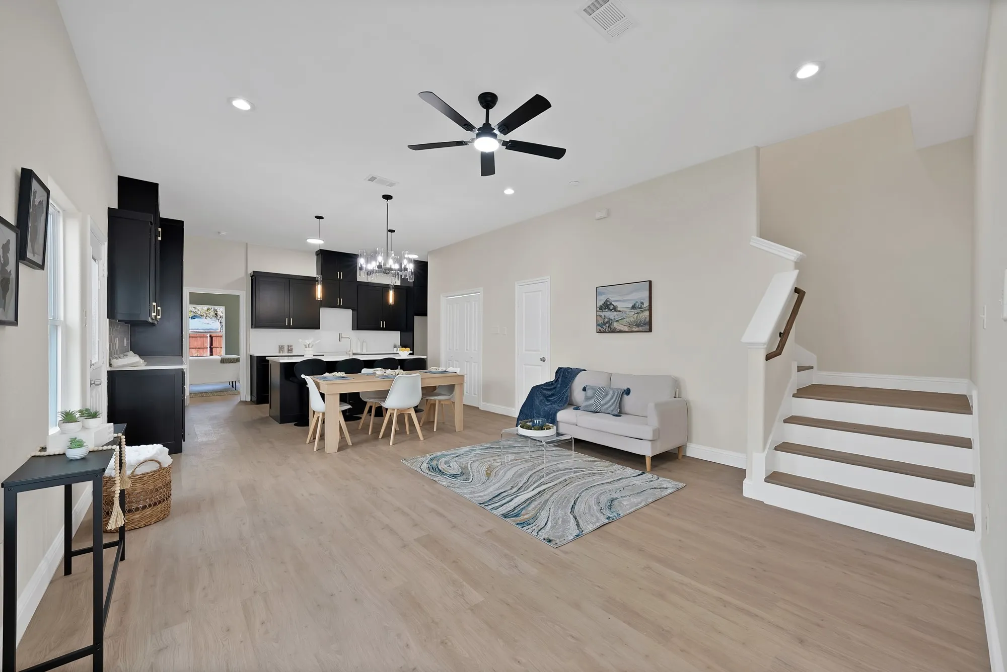 Open-concept living space featuring wood-finish flooring, recessed lighting, and a modern ceiling fan