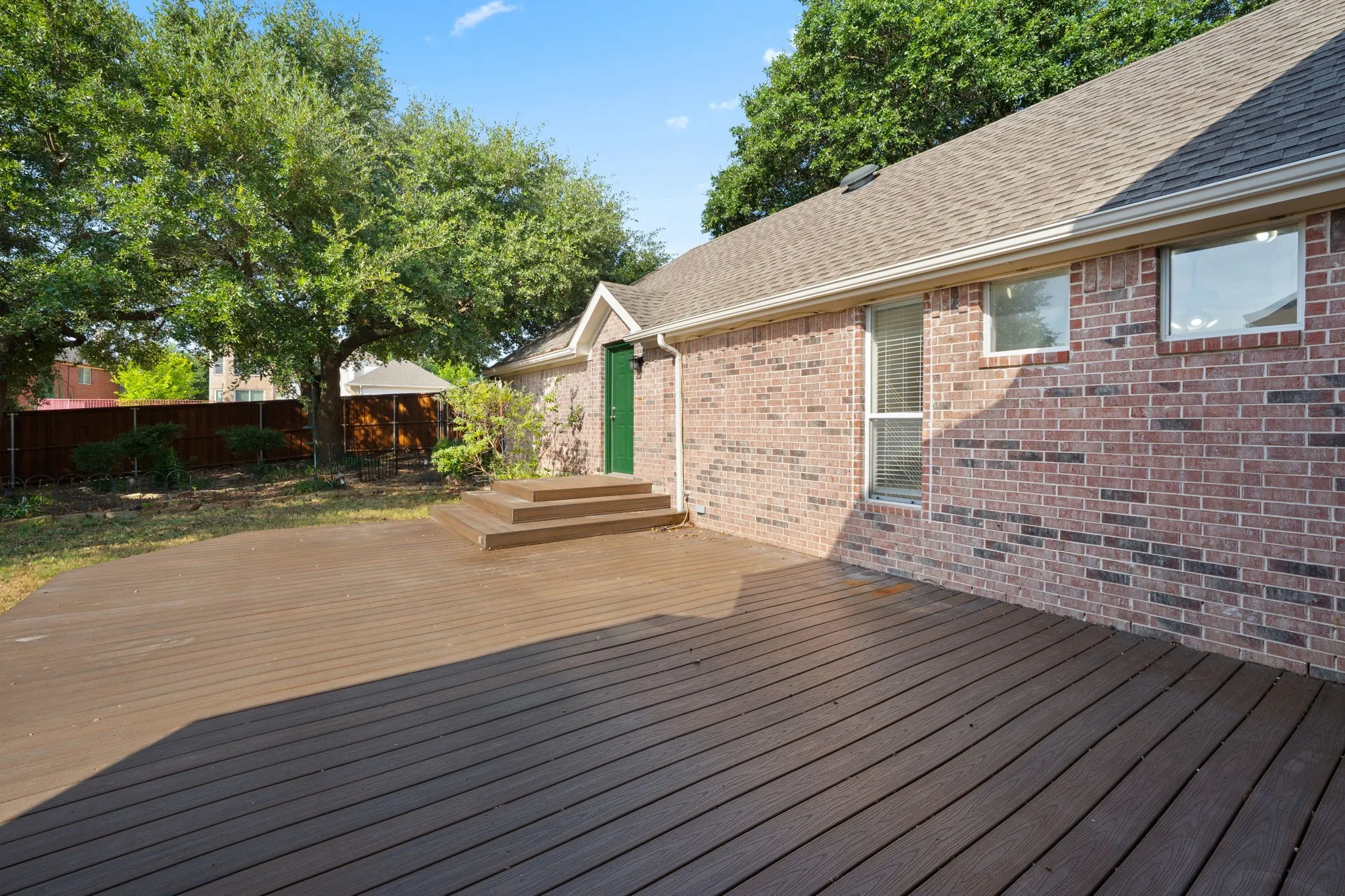 Expansive Trex deck with wood-finish planks, offering multi-level access to the structure
