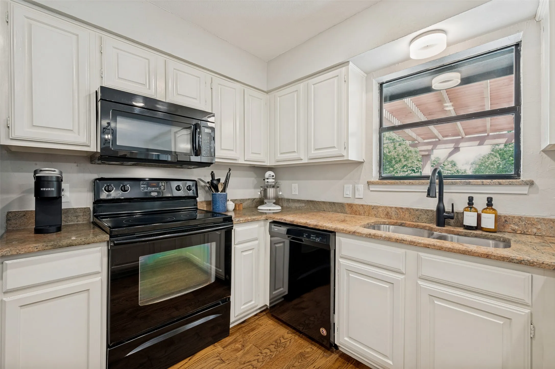Kitchen also includes  a double basin stainless steel sink with a matte black faucet, and an ideal nook for a coffee bar