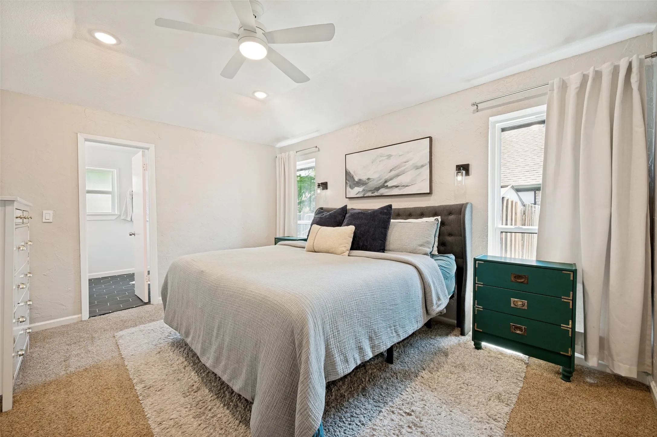 Bedroom featuring a textured accent wall, recessed lighting, and a ceiling fan