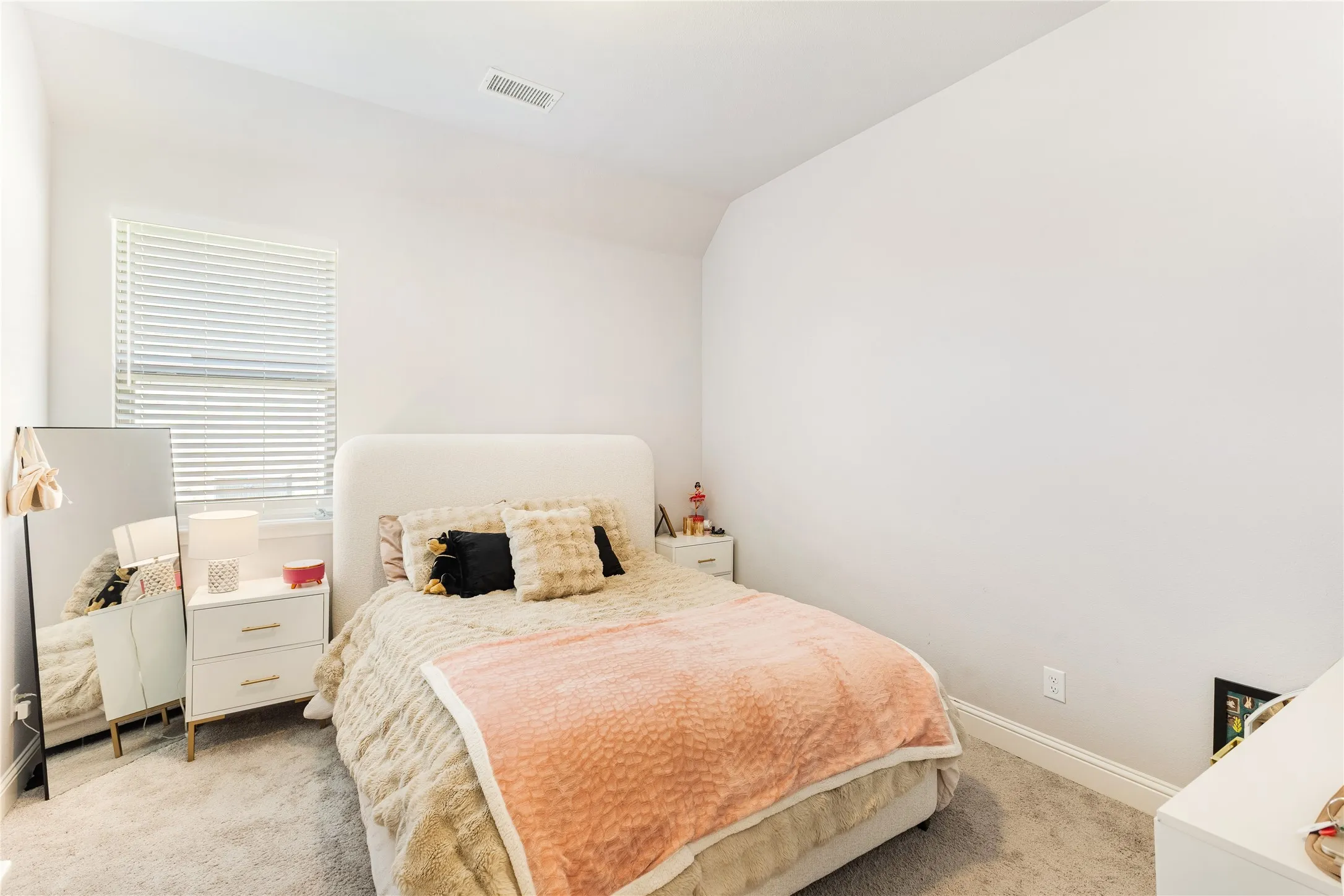 Carpeted room with a window featuring horizontal blinds
