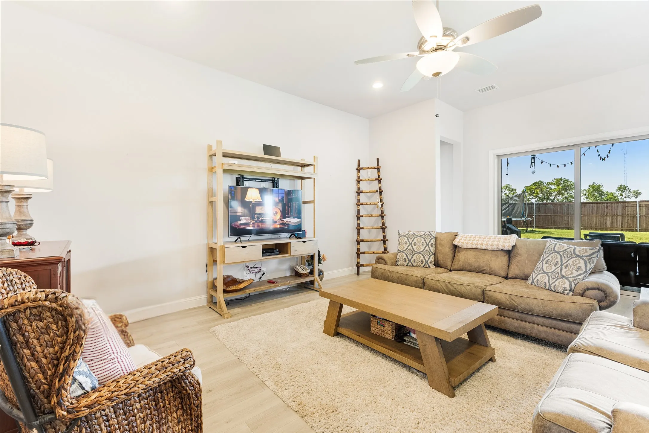 Living area featuring light wood-finish flooring, recessed lighting, and a ceiling fan