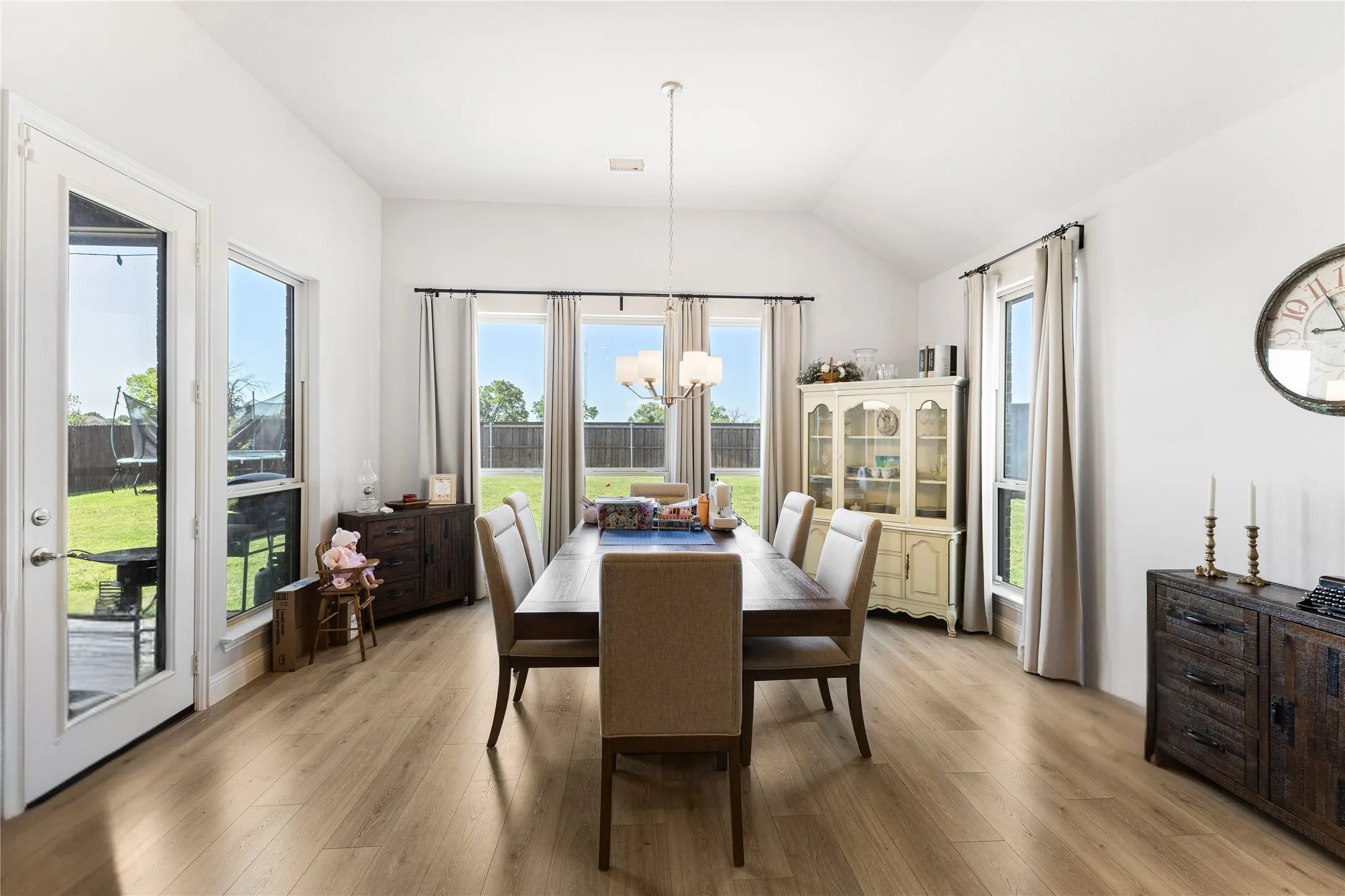 Dining area featuring light wood-finish flooring and a vaulted ceiling