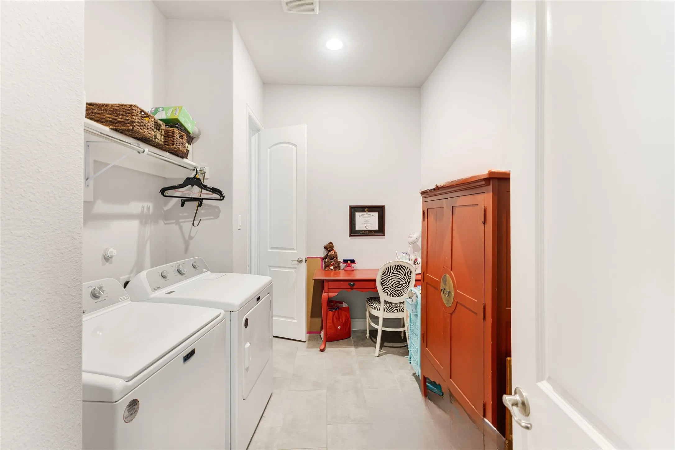 Utility room featuring light-toned flooring, white walls, and recessed lighting