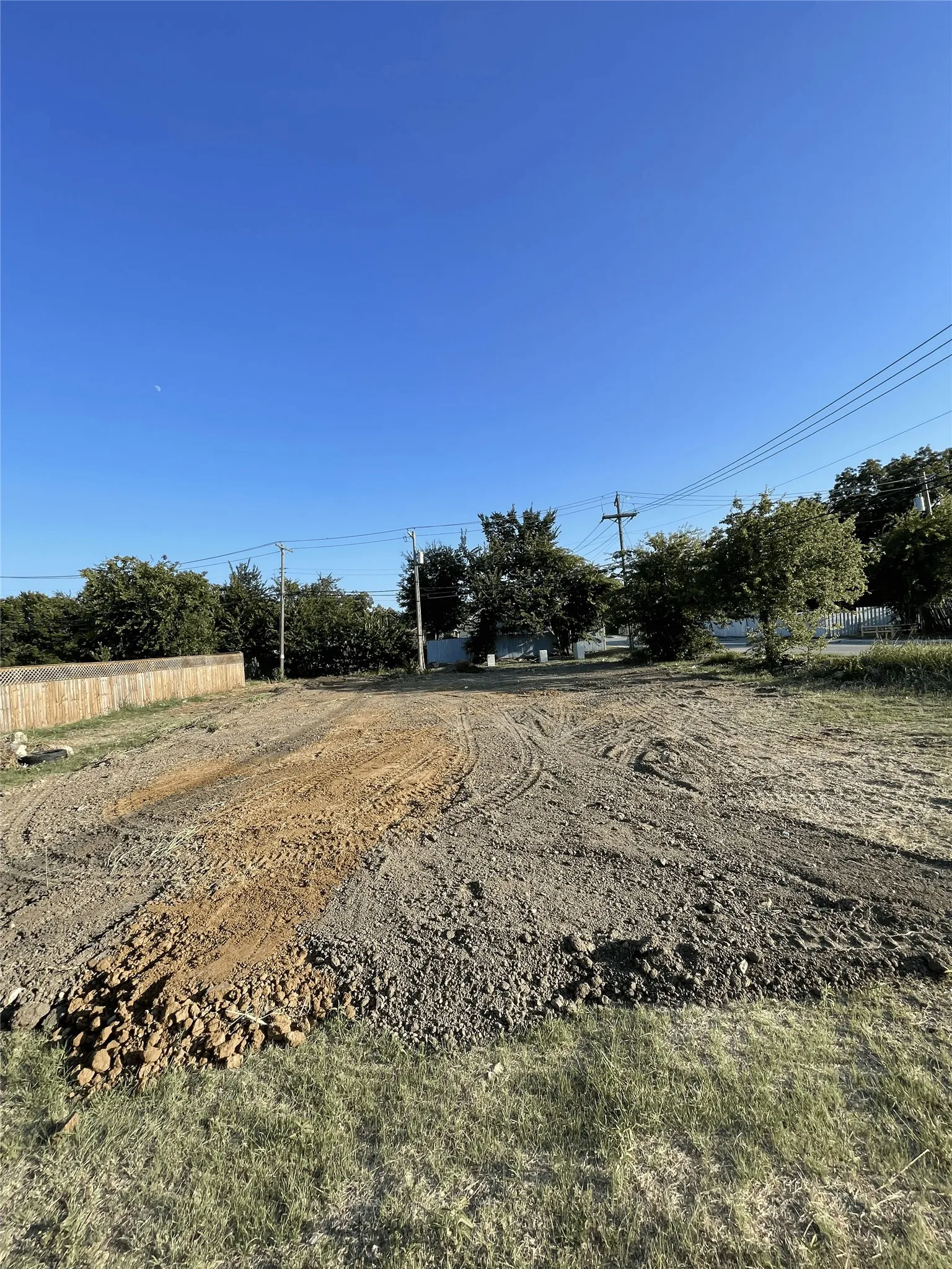 Cleared lot featuring exposed soil and surrounding natural vegetation