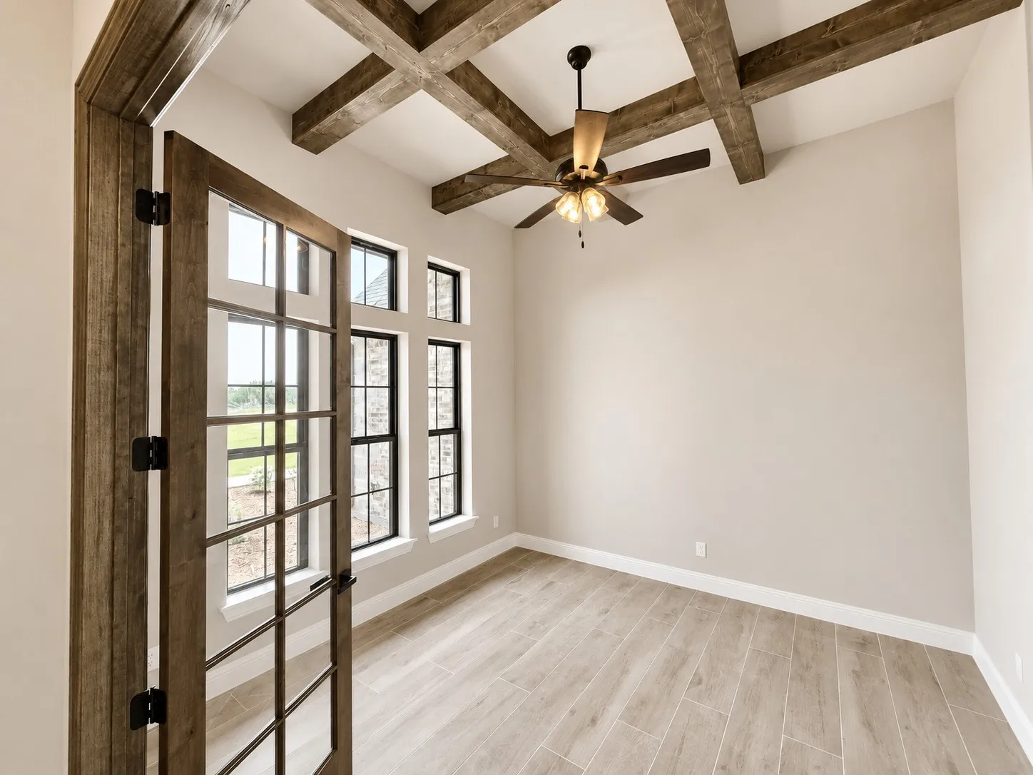 Vaulted ceiling with exposed wood beams and a ceiling fan