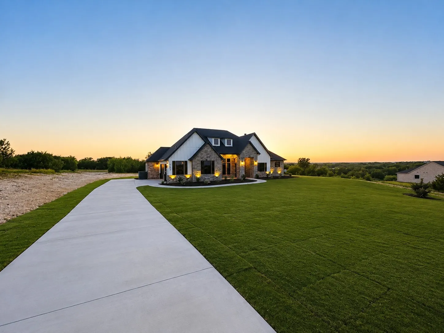 Expansive property featuring a concrete driveway and large manicured lawn