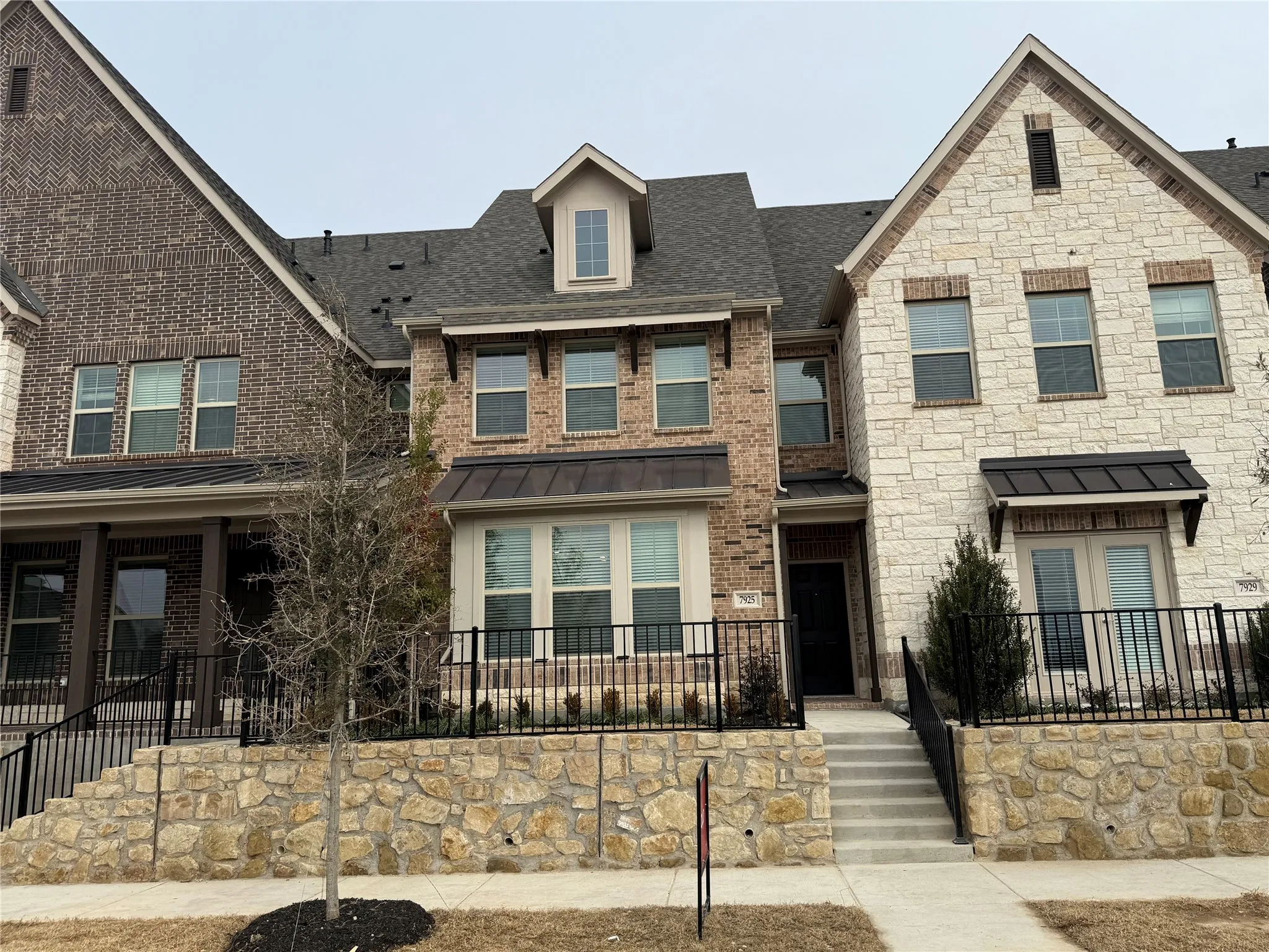 Multi-story townhouse facade showcasing a blend of brick and stone exteriors